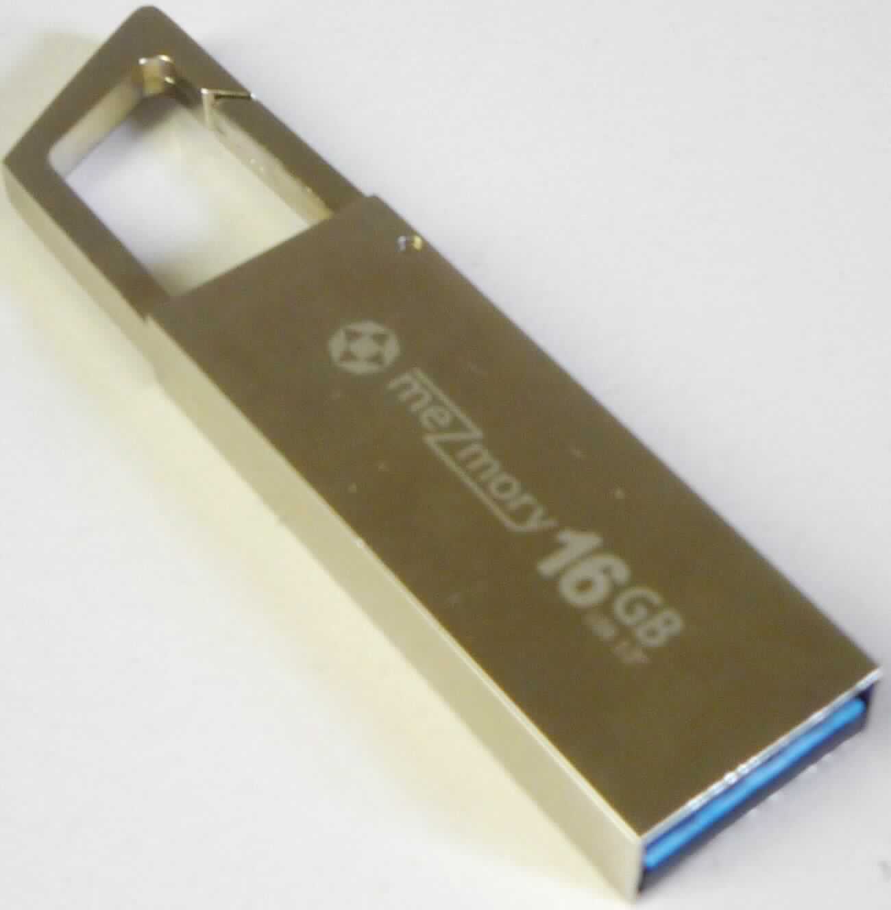 Der USB-Speicherstick mit der Bezeichnung "meZmory Grab / USB-Stick Grab" besteht im Wesentlichen aus einer mit einem Flash-Speicher und einem Chipcontroller sowie weiteren passiven diskreten Bauelementen bestückten Leiterplatte mit USB-Anschluss (USB 3.0).

Die Speicherkapazität beträgt je nach Modell 16, 32 oder 64 GB: 
- Artikel 1-30-3-40-02 mit 16 GB
- Artikel 1-30-5-40-02 mit 32 GB
- Artikel 1-30-7-40-02 mit 64 GB

Der Stick enthält keine Aufzeichnung und ist zur Datenaufzeichnung und -wiedergabe nach Anschluss an die USB-Schnittstelle unterschiedlicher Geräte bestimmt.
Das Edelstahlgehäuse des USB-Sticks verfügt über einen Karabiner zur universellen Befestigung (z. B. an Schlüsselbunden, Rücksäcken etc.)

Das Erzeugnis ist als "Halbleiter-Aufzeichnungsträger, nicht flüchtige Halbleiterspeichervorrichtung, ohne Aufzeichnung" einzureihen.

Anlage: 1 Abbildung