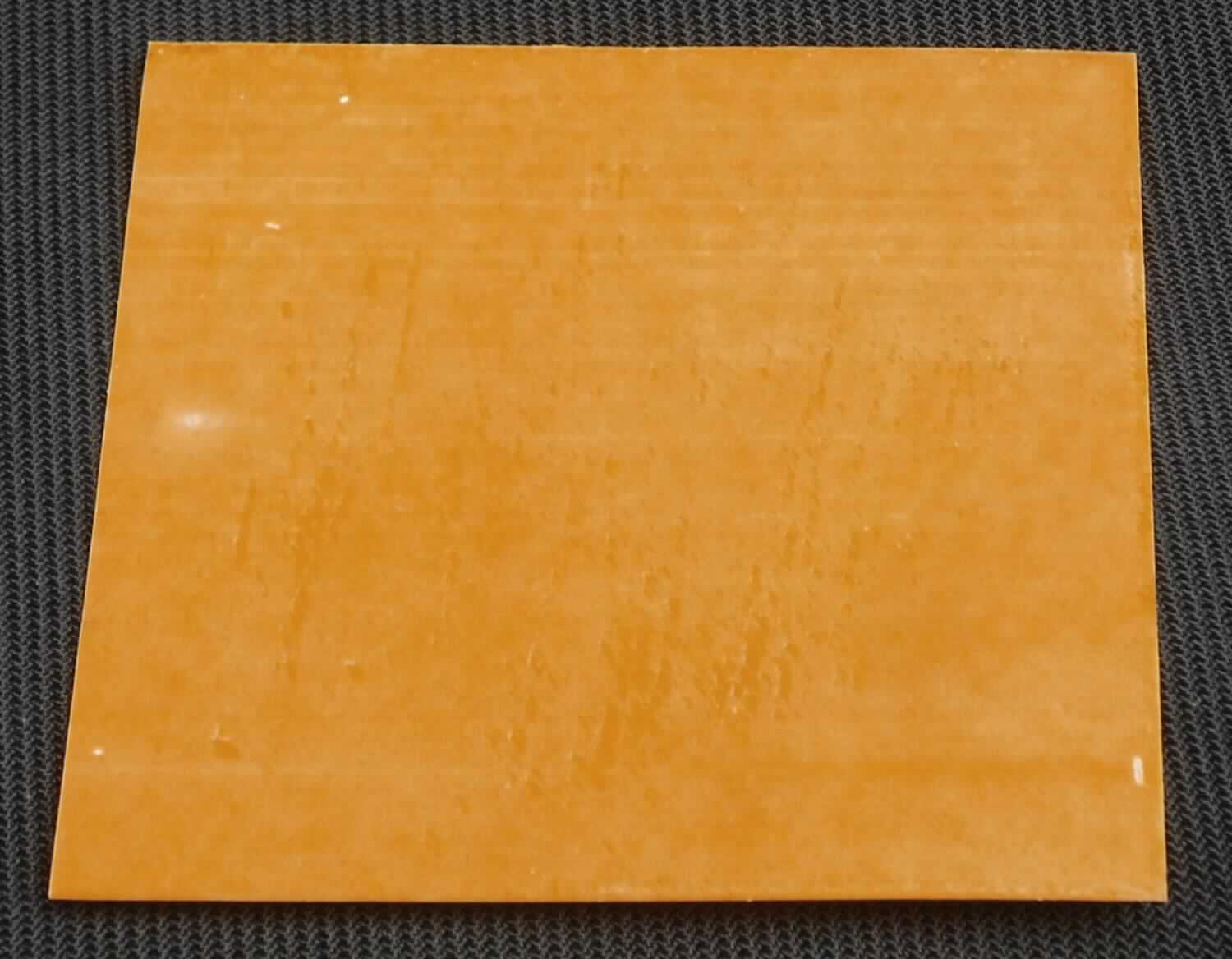 Angaben des Antragstellers:
Kapton-Film
-elektrisch isolierend und thermisch leitend-
gehandelt in Matten (z.B. 300 x 400 mm) oder Rollen (z. B. 300 mm x 50 m)

Feststellungen an einem Warenmuster:
Es wurde ein Abschnitt einer gelben Folie vorgelegt. Die Folie ist auf einer Außenseiten mit einer Schutzfolie versehen. Die gelbe Folie ist nicht selbstklebend und besteht aus Polyimid. Die gelbe Folie ist auf beiden Seiten mit einem Wachs versehen.
Die Dicke der gelbe Folie beträgt mit Beschichtung ca. 0,07 mm.

Befund:
Es liegt eine Kunststofffolie aus Polyimid im Sinne der Unterposition (KN) 3920 9928 vor.