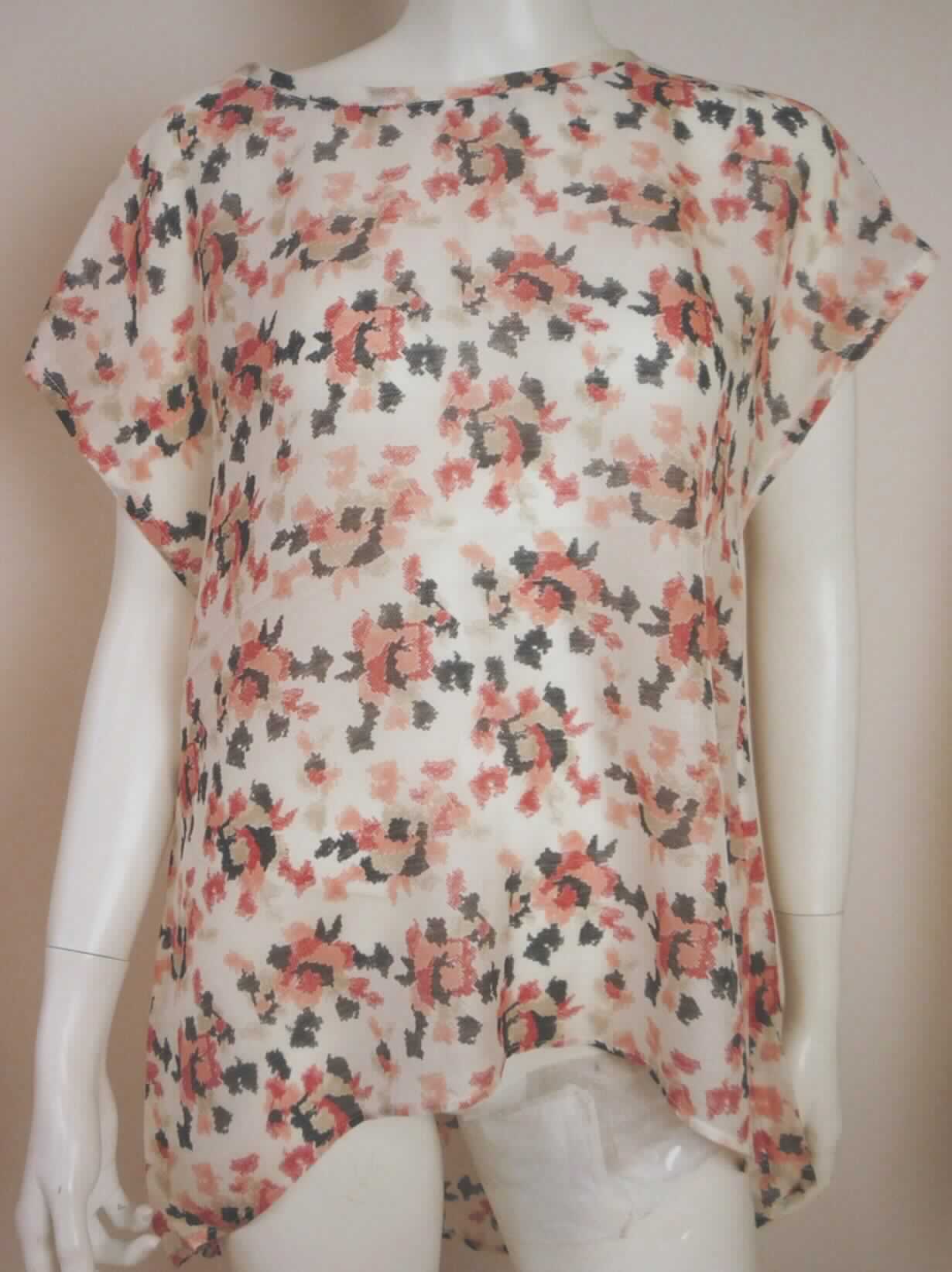 Bluse, sog. Frauenbluse Rosewhite Blouse W03097, Größe S, Foto siehe Anlage,
- aus ca. 0,3 mm dicken, buntbedruckten Geweben aus lt. Antrag 65 % Merinowolle und 35 % Seide, 
- über den Schritt reichend (Rückenlänge: ca. 73 cm), vorn bis zu 14 cm kürzer und hinten abgerundet gearbeitet, 
- mit einem runden, leicht halsfernen Ausschnitt,
- ohne Öffnung und ohne Verschluss, ohne Hinweis auf den Trägerkreis (unisex),
- mit sehr kurzen Ärmeln (sog. überschnittene Schulter),
- am unteren Rand durch Umschlagen und Festnähen gesäumt.

"Bluse, aus Geweben, für Frauen, aus Wolle"