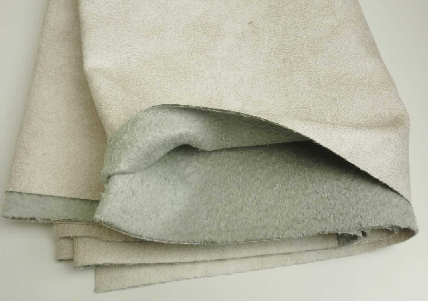 Textillaminat, Foto siehe Anlage,
- als Meterware, 
- laut Untersuchungsergebnis:
-- aus zwei mit ihrer ganzen Fläche aufeinander liegenden und so miteinander durch Kleben verbundenen Lagen: 
--- mit einer oberen Lage (Schauseite):
---- aus einem gerauten und bedruckten Gewebe in Atlasbindung aus ungezwirnten, nicht hochfesten 
      Garnen, 
---- mit Kettgarnen aus synthetischen Filamenten,
---- mit Schussgarnen aus dickeren, synthetischen Filamenten und synthetischen Mikro-Spinnfasern, 
---- alle Filamente und Fasern aus Polyester,
---- mit einem Gesamtanteil an:
----- synthetischen Filamenten von ca. 60 GHT,
----- synthetischen Spinnfasern von ca. 40 GHT,
--- mit einer Unterlage:
---- aus einem buntgewebten Gewebe (melierte Garne), 
---- aus synthetischen Filamenten und synthetischen Mikro-Spinnfasern (alle aus Polyester), wobei der Anteil 
      an Spinnfasern überwiegt,
- aufgrund der verarbeiteten Flächenerzeugnisse keine Ware des Kapitels 60,
- insbesondere im Hinblick auf die Bedeutung in Bezug auf die Verwendung verleiht das die Schauseite bildende 
  Gewebe der Ware ihren wesentlichen Charakter.

"Gewebe aus Garnen aus synthetischen Filamenten, anderes als in den Unterpositionen 5407 10 bis 5407 84
 genannte, bedruckt"