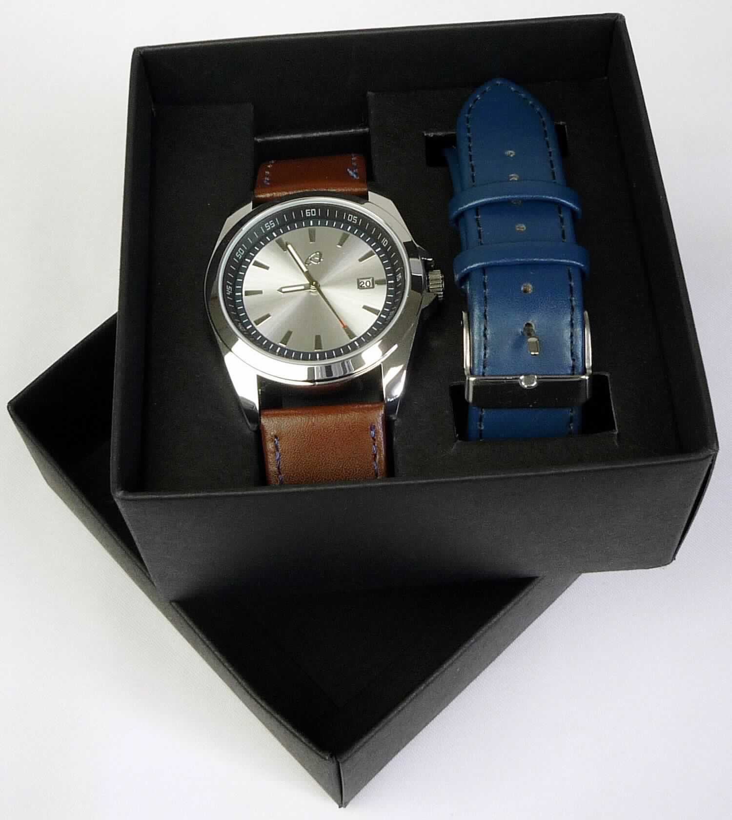 Bei dem "Analog Quarz Armbanduhren Set" handelt es sich um eine Warenzusammenstellung in Aufmachung für den Einzelverkauf, bestehend aus:
- einer Quarz-Armbanduhr mit einem Gehäuse aus Stahl, elektrisch betrieben (Batterie), mit mechanischer (analoger) Anzeige von Stunden, Minuten, Sekunden und Datum, mit einem Lederarmband mit Dornschließe;
- einem zusätzlichen Uhrarmband mit Dornschließe zum Wechseln, aus Leder;
- zwei Federstegen und einem speziellen Montagewerkzeug für den Armbandwechsel.
Charakterbestimmend ist die Armbanduhr im Hinblick auf die Bedeutung für die Verwendung.

Das Set befindet sich in einem Geschenkkarton, der mit transparenter Kunststoffbox und Bedienungsanleitung in einem bedruckten Pappkarton für den Einzelverkauf aufgemacht ist.

Die Warenzusammenstellung ist als "Armbanduhr, mit Gehäuse aus Stahl, elektrisch betrieben, mit mechanischer Anzeige" einzureihen.