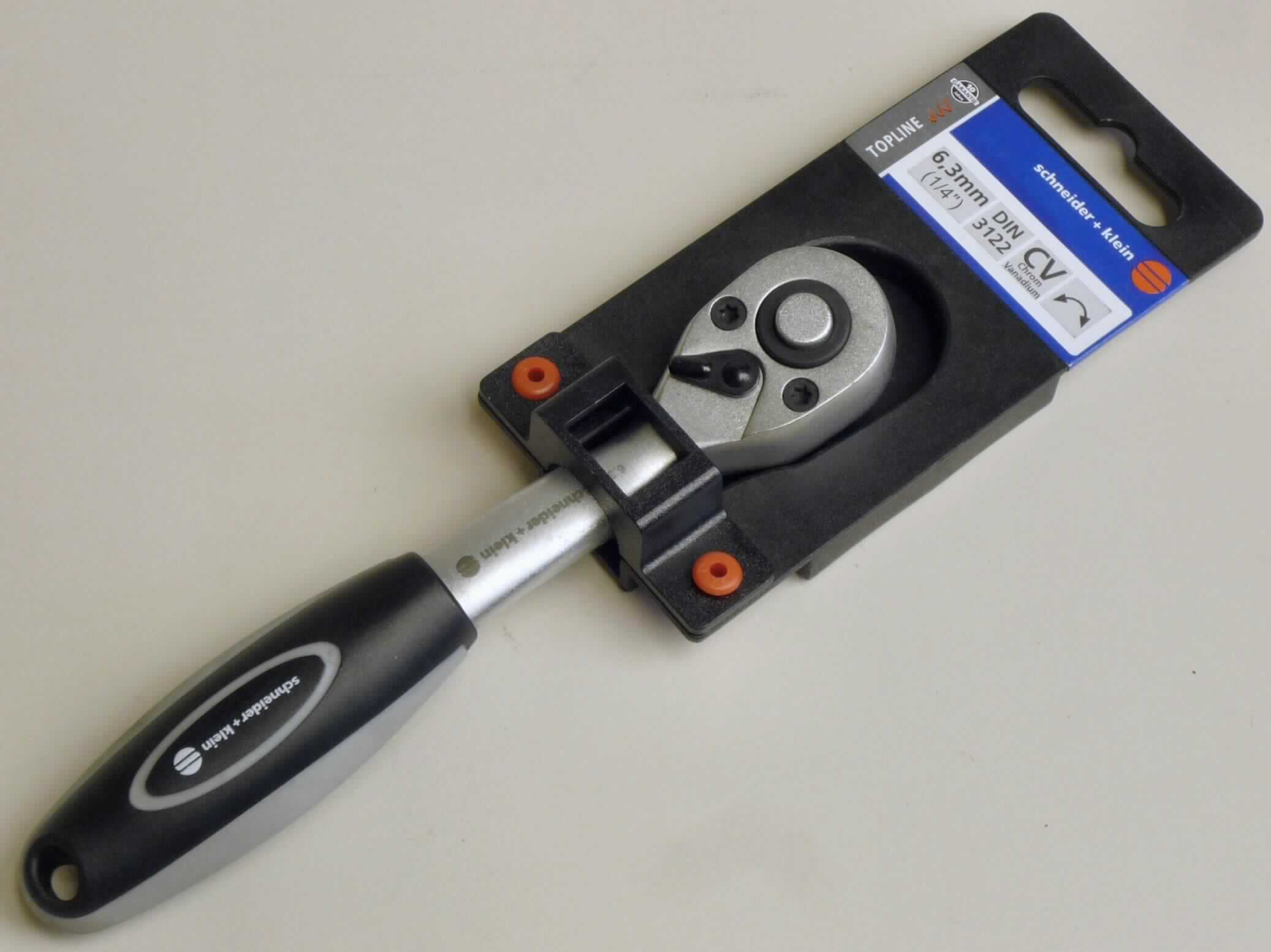 Umschaltknarre

- in Form eines Antriebsteils (Griff) für auswechselbare Steckschlüsseleinsätze 
  aus unedlem Metall, mit Griff aus Kunststoff

- umschaltbar von Rechts- auf Linksgang

- mit 1/4"-Außenvierkantantrieb aus unedlem Metall

- mit einer mittels Druckknopf zu betätigenden Schnelllösefunktion

- Länge ca. 14 cm

- auf einem Kunststoffreiter für den Einzelverkauf aufgemacht

Abbildung siehe Anlage.

Derartige Erzeugnisse gehören als "Teile aus unedlem Metall von auswechselbaren Steckschlüsseleinsätzen aus unedlem Metall mit Griff" zum TARIC-Code 8204 2000 00.