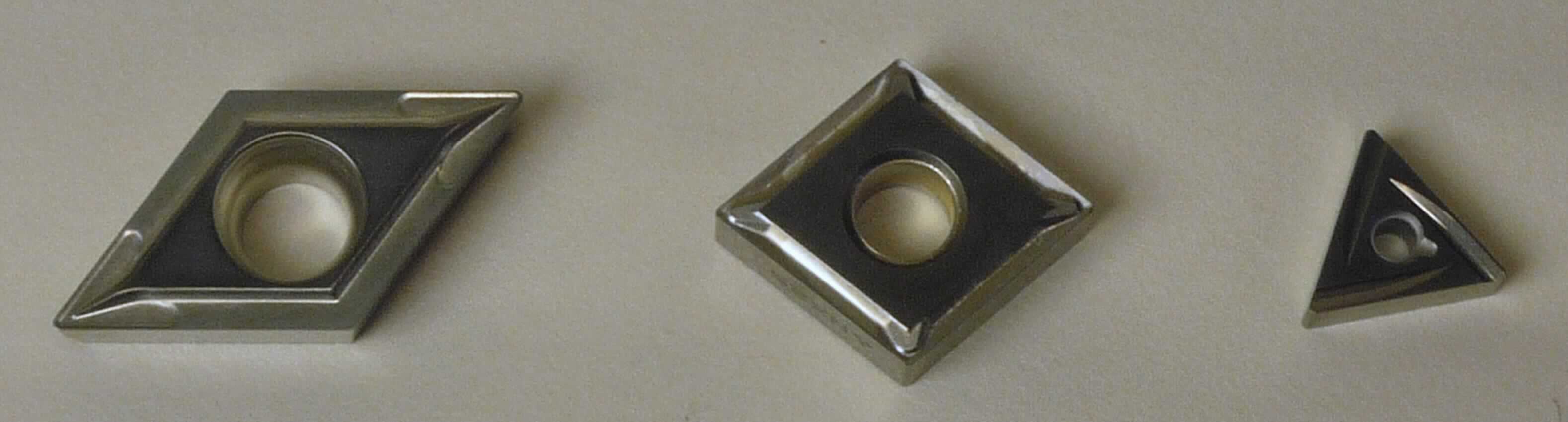 "Wendeschneidplatten"; es handelt sich um nicht gefasste, unterschiedlich geformte (z. B. dreieckig, quadratisch oder rautenförmig, auch mittig gelocht) und zum Teil mit einem dünnen Coating versehene Schneidplatten aus mit Metallen gesinterten Metallcarbiden (Cermets auf der Grundlage von Titancarbid oder Titannitrid und Nickel, Cobalt und/oder Molybdän als Bindemittel), die zwei oder mehrere Schneidkanten aufweisen. Die Erzeugnisse dienen zur Verwendung in auswechselbaren Werkzeugen für die Metallbearbeitung (Drehen, Fräsen o. ä.) und bilden dort den arbeitenden Teil.
- Antragstellerangaben -

Abbildung siehe Anlage

Derartige Erzeugnisse gehören als "Wendeschneidplatten für Werkzeuge, nicht gefasst, aus Cermets" zum TARIC-Code 8209 0020 00.