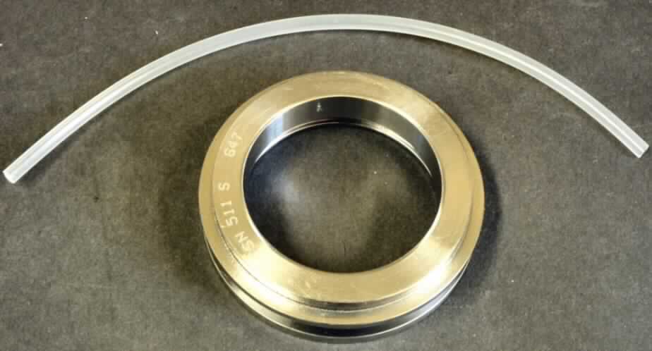 Labyrinthring für SNL-Stehlagergehäuse TSN 511S,
Gehäuseteil in Form eines kreisrunden, massiven Zylinders aus unedlem Metall, Außendurchmesser ca. 72 mm, Dicke ca. 18,5 mm, mit zwei außen umlaufenden Stegen und einer innen umlaufenden Nut, der Labyrinthring ist zusammen mit einem Silikon-Kautschuk (nach Auskunft des Beteiligten) Band in Aufmachung für den Einzelverkauf in einer Kunststofftüte verpackt.
Der Ring ist erkennbarer Bestandteil geteilter Stahllagergehäuse und bildet den Abschluss des Gehäuses zur Welle.

Die Ware ist als "Teil erkennbar hauptsächlich für Lagergehäuse von Wälzlagern aller Art, nicht für zivile Luftfahrzeuge" einzureihen.