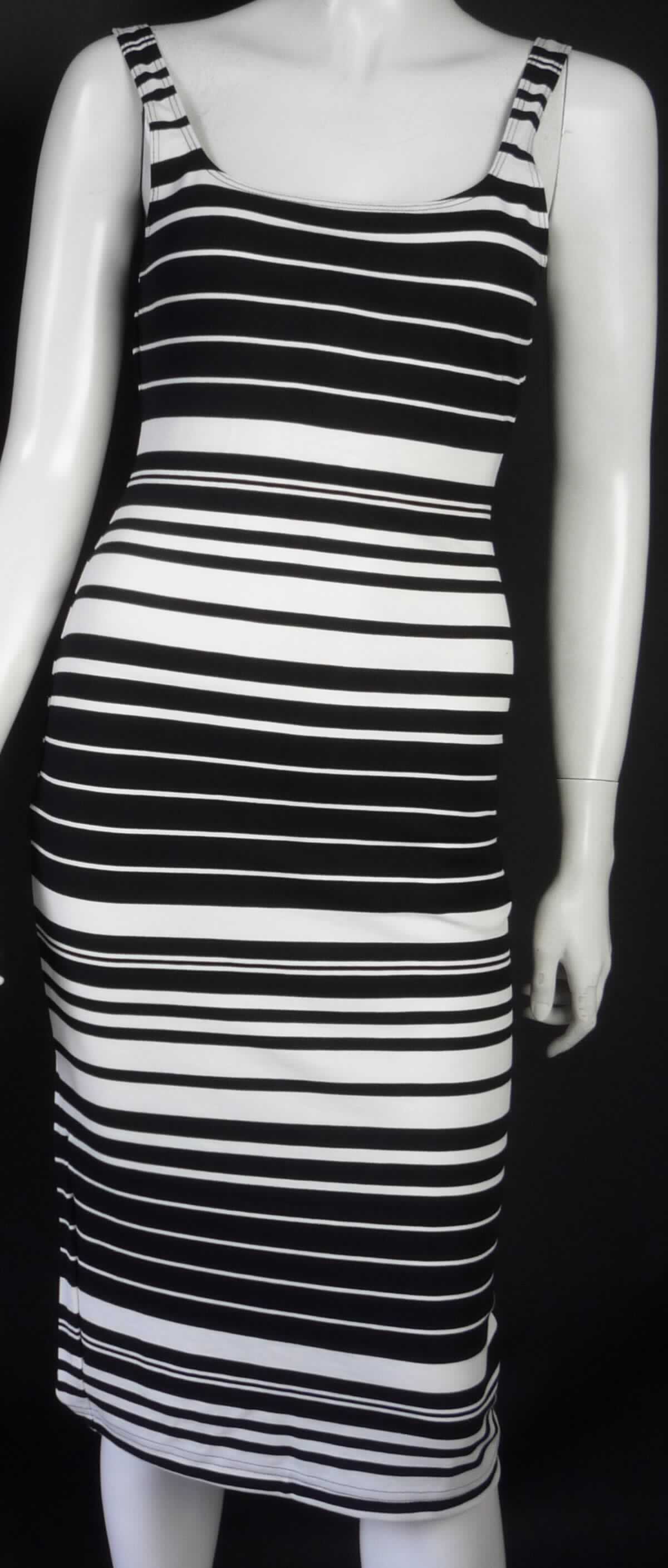 Kleid, sog. Strick Kleid, Art. RSAPO306S, Größe M, Foto siehe Anlage,
- aus ca. 0,8 mm dicken, buntgewirkten Gewirken aus laut Antrag 85 % Rayon (künstliche Chemiefasern), 
  11 % Nylon und 4 % Spandex (beides synthetische Chemiefasern),
- bis über die Knie reichend (Rückenlänge: ca. 104 cm),
- mit einem runden Halsausschnitt,
- ohne Öffnung und ohne Verschluss,
- ärmellos, 
- am unteren Rand durch Umschlagen und Festnähen gesäumt; hinten mit einem ca. 17 cm hochreichenden Schlitz 
  versehen,
- kann aufgrund der Länge ohne ein weiteres, den Unterkörper bedeckendes Kleidungsstück getragen werden.

"Kleid, aus Gewirken, für Frauen, aus künstlichen Chemiefasern"