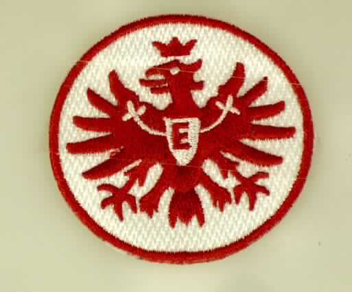Stickerei, sog. Abzeichen gestickt, Foto siehe Anlage,
- rund, mit einem Durchmesser von etwa 5 cm,
- auf einem Stickgrund aus Geweben aus laut Antrag Chemiefasern, mit Stickgarnen bestickt (Logo der Eintracht
  Frankfurt),
- auf der Rückseite (zum Aufbügeln) mit Kunststoff ausgestattet,
- nicht handgearbeitet,
- laut Antrag mit einem Wert von mehr als 17,50 EUR je kg Eigengewicht.

"Stickerei als Motiv, andere als Ätzstickereien und Stickereien mit herausgeschnittenem Grund, aus Chemiefasern,
 mit einem Wert von mehr als 17,50 EUR je kg Eigengewicht, nicht handgearbeitet"
