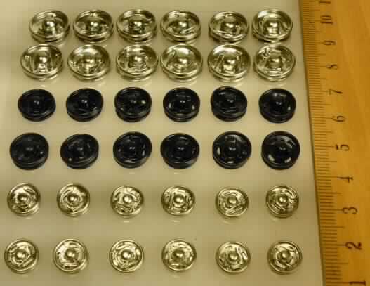 Es handelt sich um Knöpfe, sog. "Druckknöpfe", die aus unedlem Metall hergestellt sind und zum Annähen an Kleidungsstücken verwendet werden.

Die Knöpfe bestehen jeweils aus zwei Teilen.
Das eine Bestandteil besitzt in der Mitte eine runde Erhebung.
Das Gegenstück besitzt an der entsprechenden Stelle eine Öffnung, welche mittels Druck auf das o.g. Knopfteil geschlossen wird.
Die Erzeugnisse besitzen weiterhin jeweils vier Löcher, um an entsprechende Kleidungsstücke angenäht werden zu können.

Der Durchmesser der Knöpfe beträgt ca. 8 / 10 / 12 mm.
Die Knöpfe werden zu 36 Stck. (jeweils 12 Einheiten der o.g. drei Größen) auf einer Blister-Karte zum Verkauf angeboten.

Die Erzeugnisse werden als "Druckknöpfe" eingereiht.