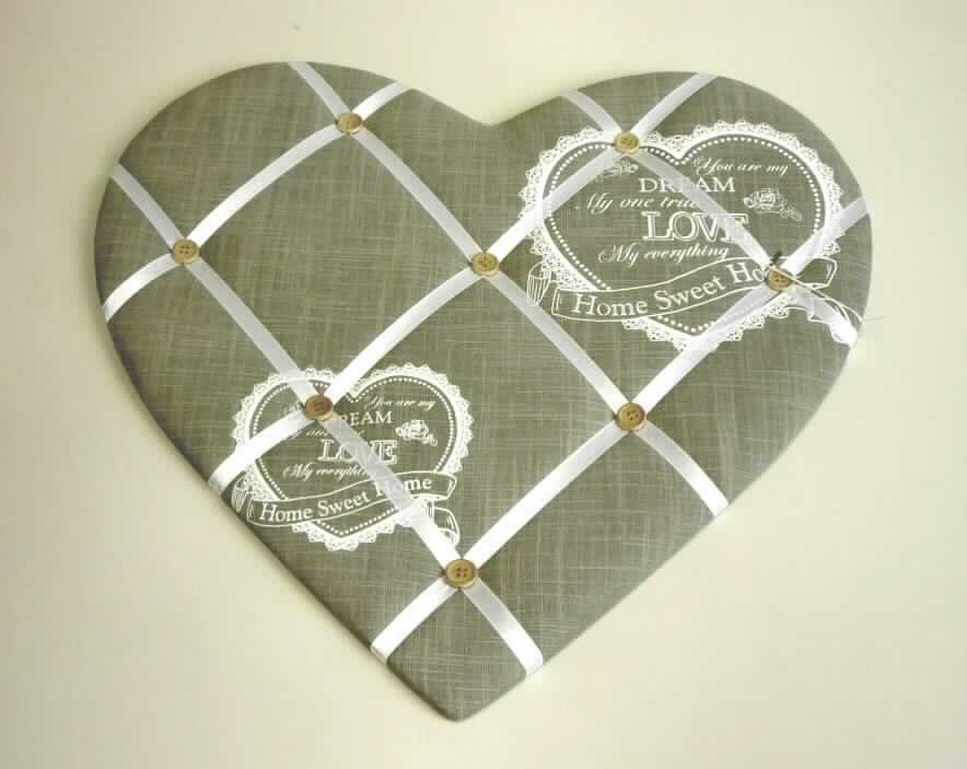 Pinnwand, sog. Kartenhalter, Art. 5236400, Foto siehe Anlage,
- in Form eines Herzens; in den Abmessungen von ca. 40 cm x 43 cm,
- bestehend aus einer MDF Platte (mitteldichte Holzfaserplatte), auf der Rückseite mit einem schwarzen 
  Vliesstoff aus Spinnstoffen und auf der Vorderseite (Schauseite) mit einem bedruckten (nicht nach dem 
  Batikverfahren handbedruckt) Gewebe aus laut Antrag 100 % Baumwolle überzogen und mit einer Lage aus 
  Schaumkunststoff leicht gepolstert, 
- auf der Schauseite der Platte mit rautenartig aufgebrachten Gewebebändern aus Spinnstoffen,
- an den Schnittpunkten der Gewebebänder mit aufgebrachten Knöpfen aus augenscheinlich Holz versehen,
- mit einer Aufhängevorrichtung aus unedlem Metall ausgestattet,
- durch Zusammenfügen konfektioniert,                          
- soll in der Art eines Wandbildes an die Wand gehängt werden und laut Antrag als sog. Kartenhalter 
  zum Unterklemmen und Anstecken von Bildern/Memos usw. dienen; stellt sich damit weder als Möbel der
  Position 9403 noch als Ware der Position 9404 dar,
- in Bezug auf die Formgebung und den Wert ist das Holz als charakterbestimmend anzusehen, im Hinblick auf die 
  Verwendung und das äußere Erscheinungsbild bestimmen die Spinnstoffe den Charakter der Ware, somit verleiht
  keiner der beiden Stoffe der Ware ihren wesentlichen Charakter und ist der von den gleichermaßen in 
  Betracht kommenden Positionen (4420 / 6304) in der Nomenklatur zuletzt genannten zuzuweisen,
- innerhalb der Position 6304 herrschen insesondere im Hinblick auf den Umfang, den Verwendungszweck und das 
  äußere Erscheinungsbild die Gewebe gegenüber den Vliesstoffen vor, sie bestimmen damit insgesamt den 
  Charakter der Ware.

"Andere Ware zur Innenausstattung (Pinnwand) aus Spinnstoffen, keine Ware der Position 9404, aus Geweben, 
 aus Baumwolle, nicht nach dem Batikverfahren handbedruckt"