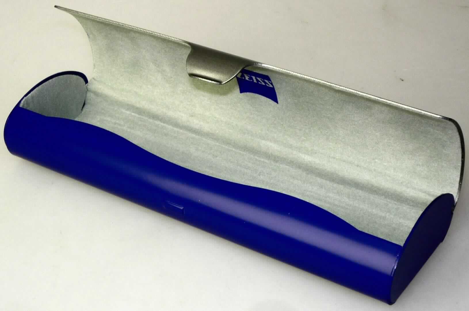 Brillenetui, Taschen- oder Handtaschenartikel, Art.-Nr. 153 990 800 00 000, Foto siehe Anlage,
- mit einer Außenseite aus unedlem Metall,
- in den Abmessungen von ca. 15 cm x 4,9 cm x 2,5 cm,
- innen mit Scherstaub beflockt,
- in Form und Größe an eine Brille angepasst,
- keine Hinweise auf Handarbeit.

"Brillenetui, Taschen- oder Handtaschenartikel, mit einer Außenseite aus unedlen 
 Metallen, nicht handgearbeitet"