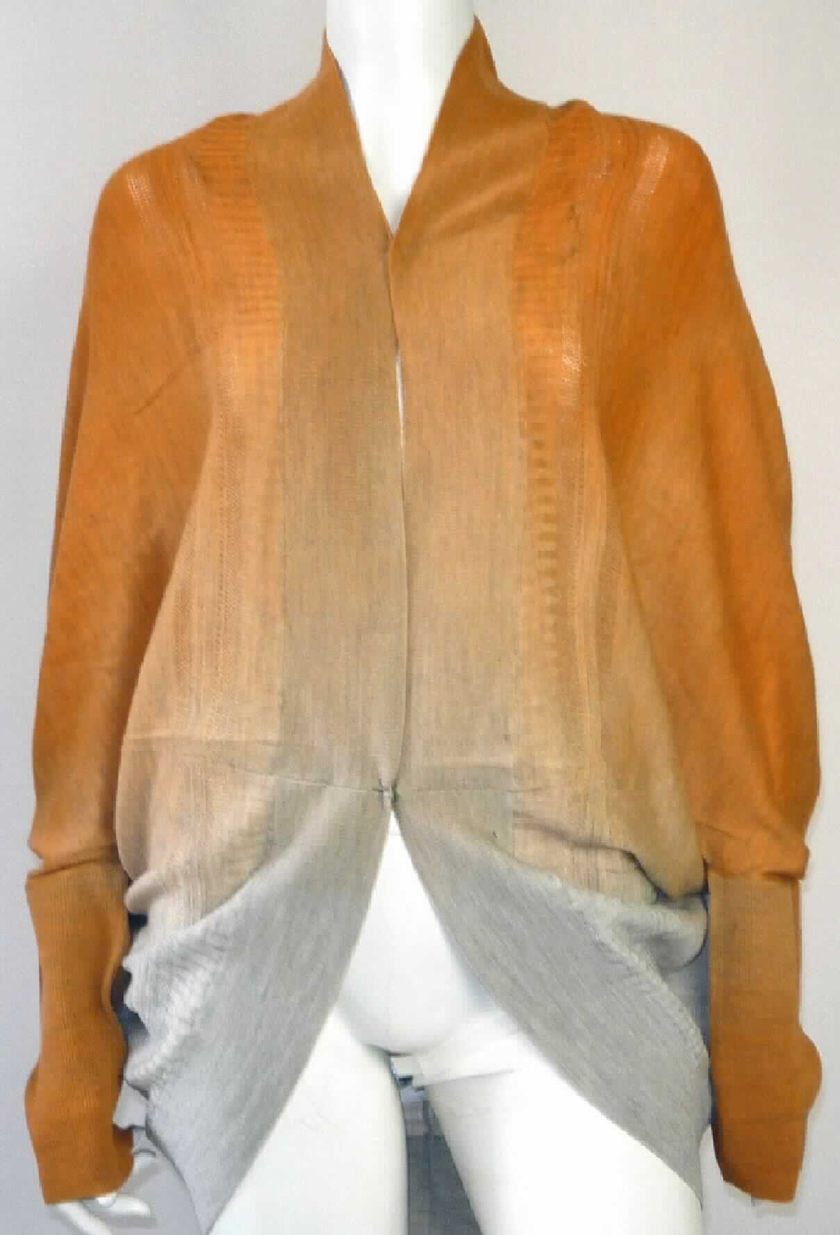 Strickjackenähnliches Kleidungsstück, sog. Cardigan für Frauen W04005 Jerilderie Wrap, Größe S, 
Foto siehe Anlage,
- aus bis zu 1,2 mm dicken, unterschiedlich strukturierten, gefärbten Gewirken aus laut Antrag 100 % Merinowolle,
- über den Schritt reichend (Rückenlänge: ca. 77 cm), 
- mit einem halsfernen, V-förmigen Halsausschnitt,
- vorn mit einer durchgehenden Öffnung, in Taillenhöhe mit einem Knopfverschluss von rechts über links 
  (Frauenkleidung),
- mit langen Ärmeln in der Art von Fledermausärmeln, 
- an den Ärmelenden sowie an allen Rändern mit abgepasst, gerippt gewirkten Abschlüssen.

"Strickjackenähnliches Kleidungsstück, aus Gewirken, aus Wolle, für Frauen"