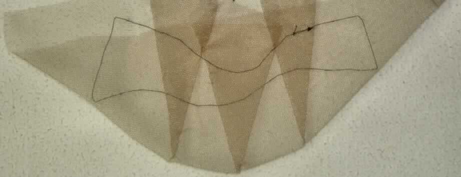 Konfektionierte Ware aus Spinnstoffen, sog. Unterbau eines Bartes, Foto siehe Anlage,
- aus einfarbigem Tüll der Position 5804,
- flachliegend in den Abmessungen von etwa 24 cm x 9 cm,
- durch Abnäher in der Form eines doppelt gearbeiteten Halbkreis zusammengenäht, somit konfektioniert,
- durch einen aufgenähten, schwarzen Faden ist der zu beknüpfende Bereich markiert,
- lt. Antrag handgearbeitet,
- soll als Unterbau ("Montur") eines Kinnbartes verwendet werden, auf dem Haare verknüpft werden,
- kein vollständiger Bart der Position 6704, weil die Montur noch nicht die wesentlichen Beschaffenheitsmerkmale 
  der fertigen Ware aufweist,
- wird als Teil eines Bartes jedoch nicht vom Warenkreis der Position 6704 erfasst,
- stellt sich nach Beschaffenheit und Material auch nicht als konfektioniertes Netz der Position 5608 dar.

"Andere konfektionierte Ware (Unterbau eines Bartes) aus Spinnstoffen, aus Tüll, handgearbeitet"