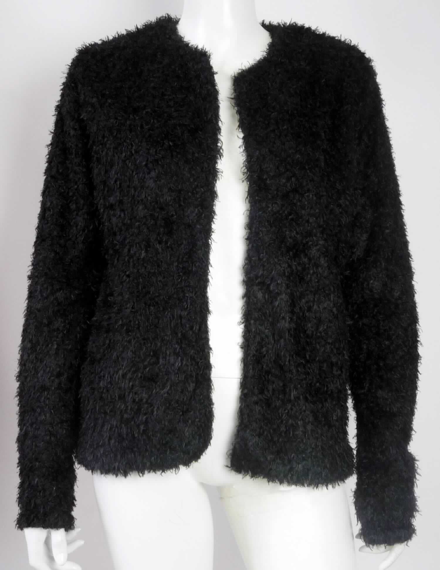 Jacke, sog. Jacke für Frauen, Art. 15-0203 // D5260U43234A, Größe M, Foto siehe Anlage,
- aus ca. 7,5 mm dicken, einfarbigen Plüschgewirken aus laut Antrag 100 % Polyester (synthetische 
  Chemiefasern),  
- durchgehend leicht gefüttert,
- über die Taille reichend (Rückenlänge: ca. 64 cm), 
- mit einem runden Halsausschnitt,
- vorn mit einer durchgehenden Öffnung ohne Verschluss,
- ohne Hinweise auf den Trägerkreis (unisex),
- mit langen Ärmeln, 
- in Längsbahnen gearbeitet, 
- am unteren Rand durch Umschlagen und Festnähen gesäumt,
- aufgrund des verwendeten Flächenerzeugnisses keine Ware des Kapitels 62.

"Jacke, aus Gewirken, für Frauen, aus synthetischen Chemiefasern"