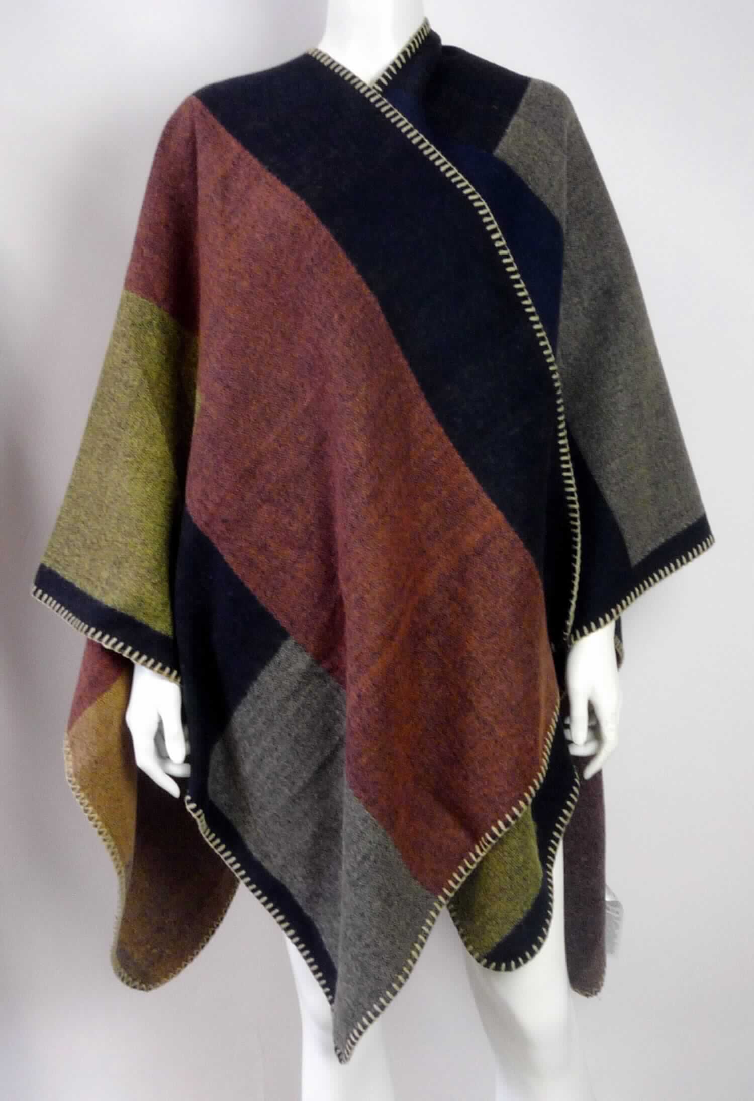 Umschlagtuchähnliche Ware, sog. Bekleidung für Frauen, Art. 15-0288 // D9080N90417ARS, Foto siehe Anlage,
- aus ca. 1,6 mm dicken, buntgewebten Geweben aus laut Antrag 100 % Polyacryl (synthetische Chemiefasern), 
- rechteckig; in den Abmessungen: ca. 138 cm (Breite) x 150 cm (Länge),
- in der Mitte einer Schmalseite mit einer bis etwa zur Mitte der Länge reichenden Aussparung,
- ohne Verschluss,
- an den Rändern durch Überwendlichnähte gesäumt (somit konfektioniert),
- vorn und seitlich offen; die Schultern, Teile der Arme und den Oberkörper bedeckend (somit kein umhang-
  ähnliches Kleidungsstück der Position 6202), 
- ohne Hinweise auf Handarbeit,
- aufgrund der verwendeten Flächenerzeugnisse keine Ware des Kapitels 61.

"Umschlagtuchähnliche Ware, aus Geweben, aus synthetischen Chemiefasern, nicht handgearbeitet"