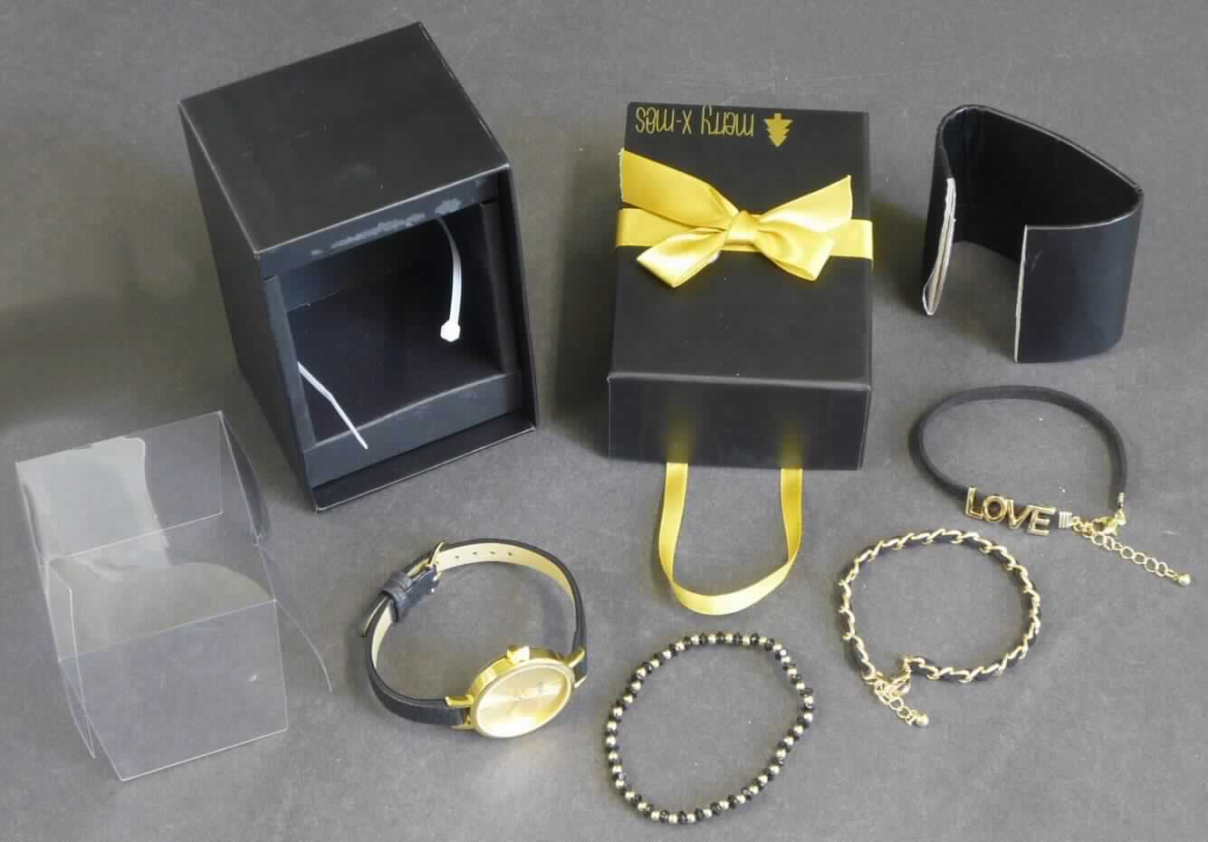 Es handelt sich um einen Bestandteil des Art. 388-263 "Uhr und Armbänder in Geschenkverpackung"-Sets, in Form einer Armbanduhr, elektrisch betrieben (Batterie), mit mechanischer Anzeige (Stunde, Minute, Sekunde), einem Gehäuse (Durchmesser ca. 3 cm) aus unedlem Metall und einem Armband aus Polyester mit einer Schließe aus unedlem Metall.

Die Uhr ist gemeinsam mit drei Armbändern (nicht Gegenstände dieser vZTA) in einem Geschenkkarton mit entsprechendem Pappeinlieger zur Auffädelung der Uhr und Armbänder verpackt. Die Bestandteile des Sets sind aufgrund des fehlenden gemeinsamen Bedarfes getrennt voneinander einzureihen.

Die Uhr ist als "andere als in Position 9101 erfasste Armbanduhr, elektrisch betrieben, nur mit mechanischer Anzeige" einzureihen.