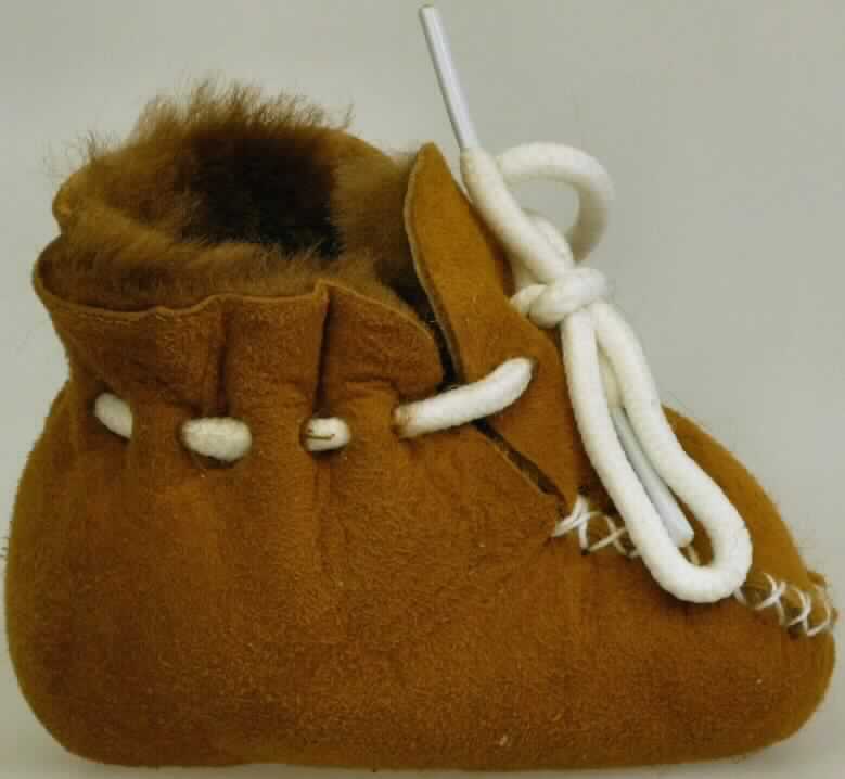 Babyschühchen (lt. Antrag: "Lammfellbabyschuhe", Foto siehe Anlage)
- mit Laufsohlen und knöchelbedeckendem Oberteil aus Pelzfell; 
  nach Art der Indianer-Mokassins gefertigt, die Laufsohle und ein 
  Teil des Oberteils bestehen aus einem Stück; als Oberteil gilt der 
  Teil des Schuhs, der die Seiten und den Rist des Fußes bedeckt,
- auf dem Blatt mit herzförmiger Lochung versehen,
- mit Schnürsenkelverschluss

"Schuhe mit Laufsohlen und Oberteil aus Pelzfellen"
