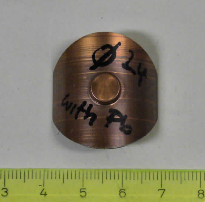 Teil eines Lenkgetriebes für Kraftfahzeuge, sog. Plasik sheed of Rack guide (Kunststoffplatte eines Führungsgleitelements), Foto siehe Anlage
- nahezu ovale, zu einem Halbkreis gebogene, ca. 1 mm starke Platte; Maße im gebogenen 
  Zustand: Höhe ca. 9 mm, Breite ca. 26 mm Tiefe 30 mm; mittig mit einer konvexen, im 
  Durchmesser  6 mm großen Vertiefung,
- bestehend aus 
 - - einer Gleitschicht aus Kunststoff (Polytetrafluorethylen -PTE-), einer Zwischenschicht aus 
     Sinterbronze und einem Rücken aus Stahl
 bzw.
- - einem ölimprägnierten Kunststoff (Polyacetal, Polyoxymethylen -POM-)
- erkennbares Teil einer Zahnstangenführung eines Lenkgetriebes für PKW (keine Ware der 
  Position 8483),

"Teile für Kraftfahrzeuge der Position 8703 (Teil einer Zahnstangenführung), Teil eines Lenkgetriebes, nicht für die industrielle Montage, nicht aus gesenkschmiedetem Stahl"