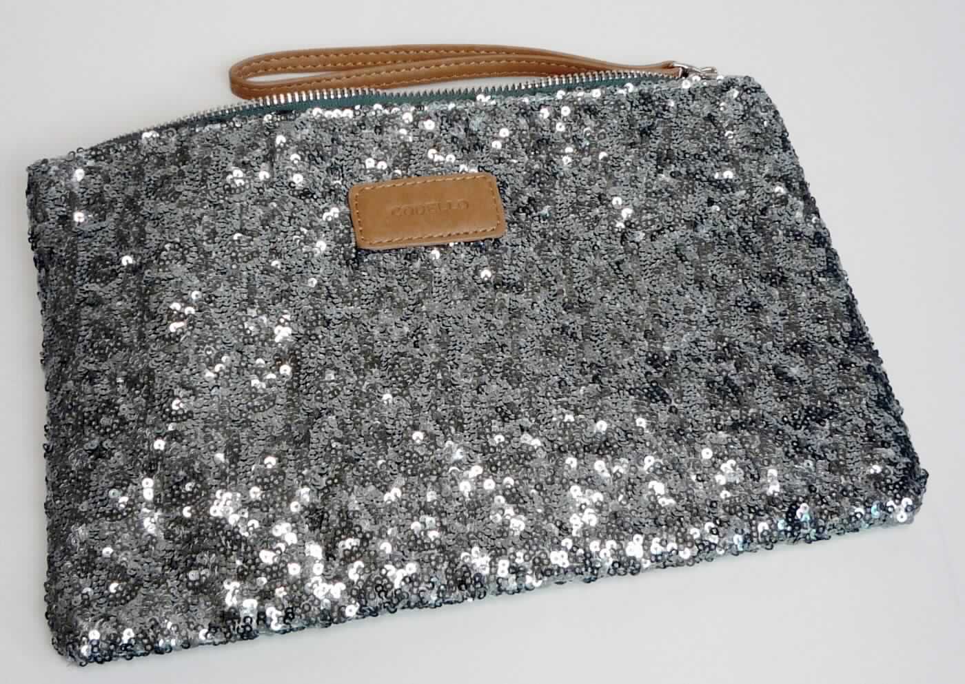 Handtasche, ROL - CODELLO, Tasche, Foto siehe Anlage,
- mit einer Schauseite aus mit Pailletten bestickten Gewirken aus Spinnstoffen der Position 5810
  (Applikationsstickerei),
- - mit einer Außenseite aus Pailletten aus Kunststoff, die das Gewirke aus Spinnstoffen vollständig bedecken
    und den mit bloßem Auge wahrnehmbaren Stoff an der Oberfläche des Behältnisses bilden, 
- an der Rückseite mit einer Außenseite aus Geweben aus Spinnstoffen,
- die Kunststoffpailletten bestimmen nach dem äußeren Erscheinungsbild (Schauseite) den wesentlichen
  Charakter der Außenseite des Behältnisses,
- mit einer Handschlaufe,
- am oberen Rand mit einem Reißverschluss,
- innen gefüttert und mit einem Fach mit Reißverschluss ausgestattet,
- in den Abmessungen: ca. 27 cm (Breite) x 19 cm (Höhe) x 1 cm (Tiefe),
- aufgrund der Form, der Größe und des Gesamteindrucks in erster Linie dazu geeignet, kleinere persönliche
  Gegenstände aufzunehmen.

"Handtasche, mit einer anderen Außenseite als in den Unterpositionen 4202 2100 bis 4202 2290 genannte"