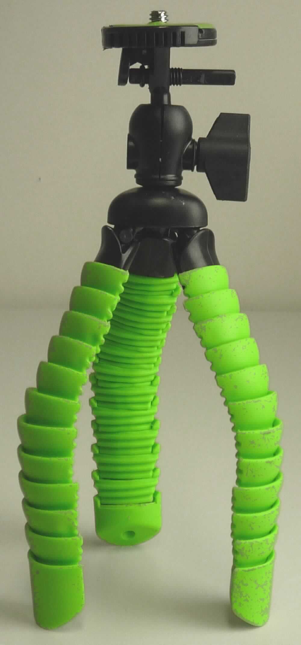 Sog. Table Tripod, im Wesentlichen bestehend aus einem Ständer mit drei Flexbeinen aus grünem Kunststoff in schuppenähnlicher Struktur, die besonders flexibel und biegsam sind sowie einem Stativkugelkopf mit Schnellwechselplatte.

Der Stativkugelkopf wird mit einer Handschraube fixiert und ist horizontal um 360° frei drehbar. Die Montage der Kamera erfolgt über ein Außengewinde auf die grün eingefärbte, parabelförmige Schnellwechselplatte, welche durch einen Entriegelungsknopf mit Fixierstift befestigt bzw. gelöst werden kann. Das Stativ bietet neben dem sicheren Stand durch die kugelgelagerten Gummifüße, auch die Möglichkeit der Fixierung an Stangen, Geländern, Ästen usw. und eignet sich daher besonders für schwieriges Gelände.

äußere Form: siehe Abbildung in der Anlage

Die Ware ist in einem Karton verpackt und wird als "Zubehör, erkennbar hauptsächlich für Fotoapparate bestimmt" eingereiht.