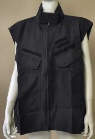 Weste für Männer, sog. "Weste, Blackhawk 87HP25", Größe 2XL, Foto siehe Anlage,
- aus 0,4 mm dicken, einfarbigen Geweben aus laut Antrag 70% Baumwolle und 30% Nylon (synthetische
  Chemiefasern), 
- über die Taille reichend (Rückenlänge: 77 cm, vorn etwa 9 cm kürzer gearbeitet),
- mit einem Stehkragen, mit einem Klettverschlussriegel von links über rechts (Männerkleidung),
- vorn mit einer durchgehenden Öffnung mit Reißverschluss,
- ärmellos,
- vorn mit verschiedenen Taschen,
- am unteren Rand gesäumt.

"Andere Kleidung (Weste), aus Geweben, für Männer, aus Baumwolle, keine Arbeits- und Berufskleidung"