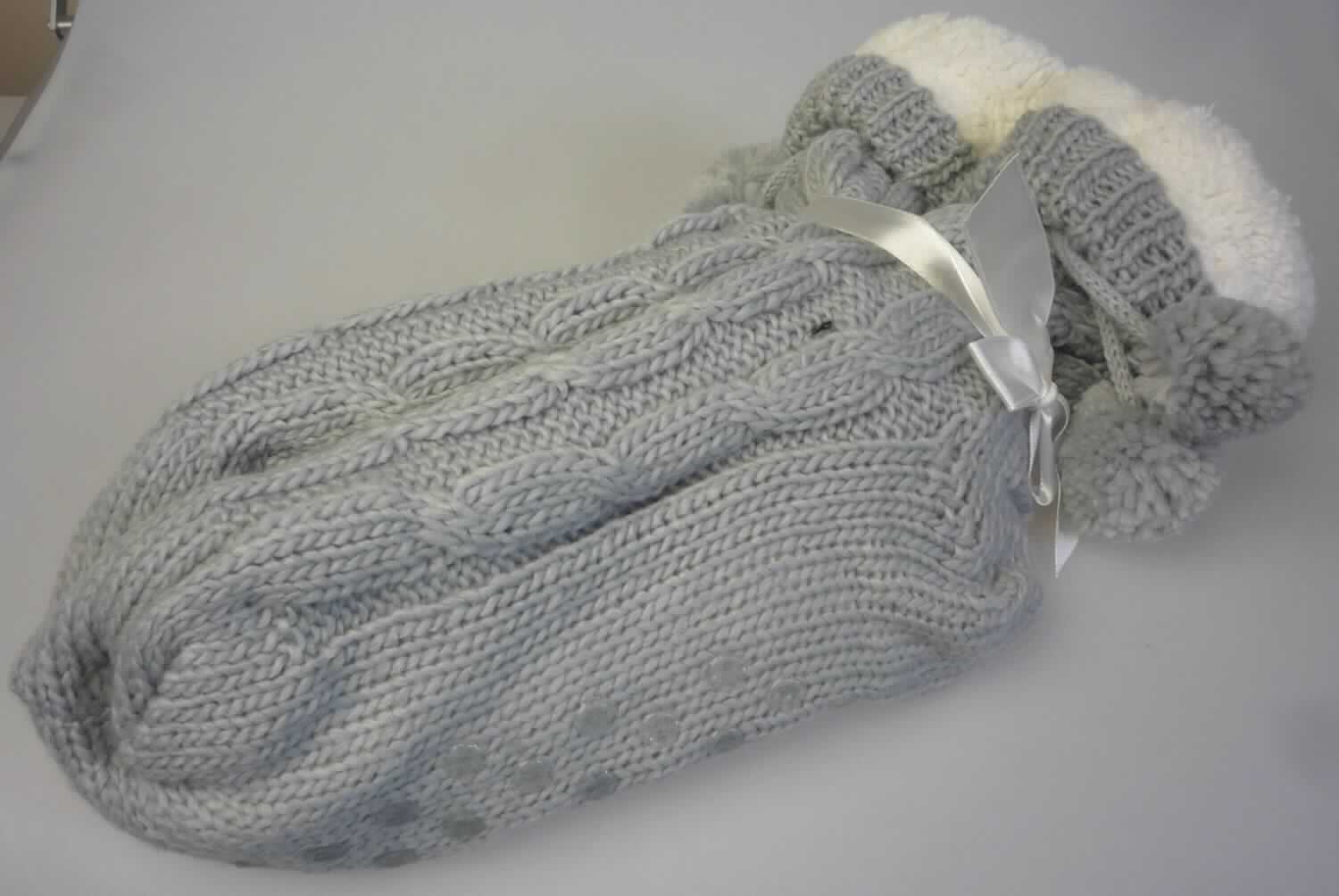 Socken, sog. Homesocks mit ABS, Art. 7196071, Größe 39-42, Foto siehe Anlage,
- paarweise auf eine bedruckte Pappkarte aufgebracht und mit einer Gewebeschleife versehen,
- doppellagig gearbeitet, mit einer Außenseite aus einfarbigen, musterbildend gestrickten Gestricken aus laut 
  Antrag 100 % Polyacryl und einer Innenseite aus einfarbigen Plüschgewirken aus laut Antrag 100 % Polyester
  (beides synthetische Chemiefasern), 
- am oberen Abschluss mit angehängten "Bommeln" verziert,
- durch Zusammennähen konfektioniert,
- die Knöchel bedeckend, nicht bis zur Mitte der Wade reichend,
- zur Erhöhung der Rutschfestigkeit auf der Lauffläche mit Noppen, die keine angebrachte Laufsohle darstellen, 
  somit keine Schuhe.

"Socken, aus Gestricken, aus synthetischen Chemiefasern"