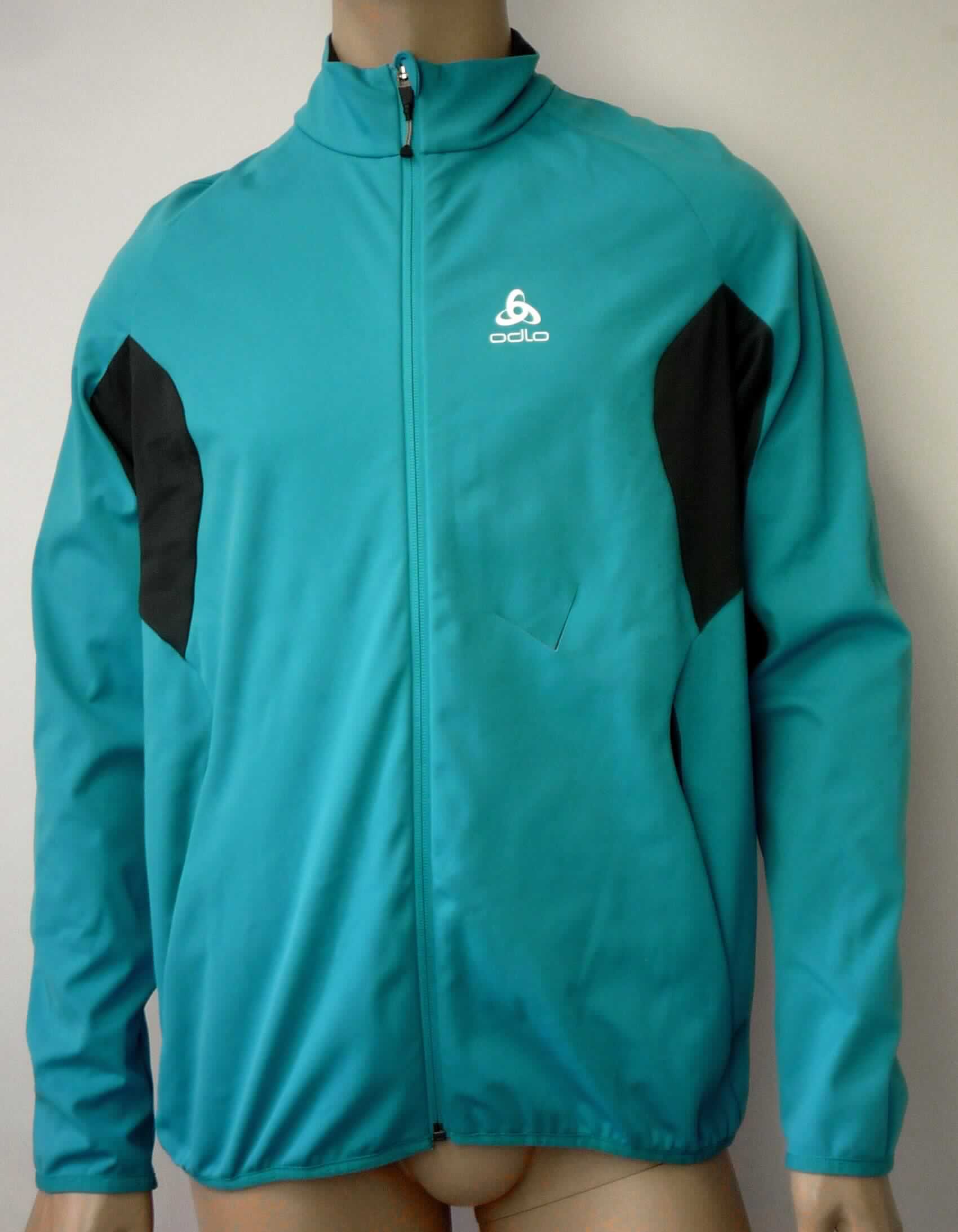 Blouson, sog. Softshelljacke, Größe XL, Foto siehe Anlage,
- aus ca. 1,0 mm dicken, zweilagigen, durch Kleben miteinander verbundenen Flächenerzeugnissen mit einer
  Außen- und Innenlage aus einfarbigen Gewirken aus laut Antrag 100 % Polyester (synthetische Chemiefasern);
  im Bereich der Arme und am Rücken aus 0,6 mm dicken, einfarbigen Gewirken aus laut Antrag 100 % Polyester,
- über die Taille reichend (Rückenlänge: ca. 75 cm), hinten abgerundet und vorn bis zu ca. 9 cm kürzer 
  gearbeitet,
- teilweise gefüttert,
- mit einem Stehkragen,
- vorn mit einer durchgehenden Öffnung mit einem bis in die Kragenspitzen reichenden Reißverschluss, am 
  Kragenrand mit einer kurzen Überlappung von links auf rechts (Männerkleidung),
- mit langen Ärmeln, die über den unteren Rand des Kleidungsstücks hinausreichen; an den Ärmelenden 
  mit einem verengenden Abschluss,
- mit zwei eingesetzten Taschen mit Reißverschluss unterhalb der Taille,
- am unteren Rand mit einem verengenden Abschluss, 
- erfüllt die Merkmale zur Einreihung als Blouson, somit keine Jacke,
- aufgrund der verwendeten Flächenerzeugnisse keine Ware des Kapitels 62.

"Blouson, aus Gewirken, für Männer, aus Chemiefasern"