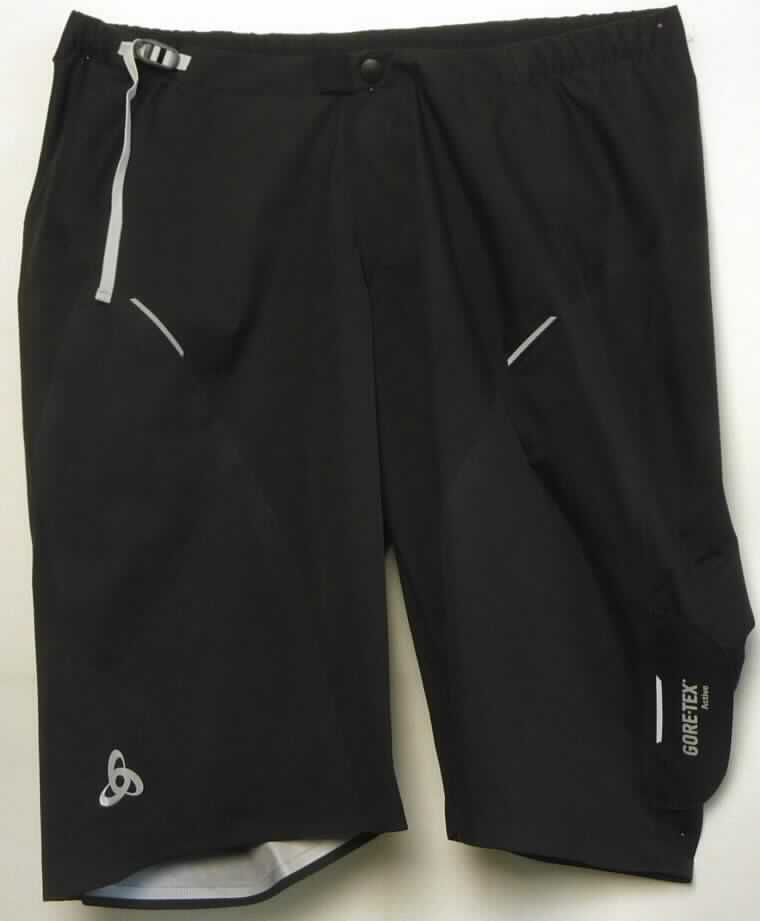 Kurze Hose, sog. Shorts gore-tex MOLINA, Art. 421810, Größe L, Foto siehe Anlage,
- bestehend aus mehreren, musterbildend zusammengenähten Zuschnitten aus zwei unterschiedlichen, dreilagigen 
  Flächenerzeugnissen:
-- aus einem ca. 0,3 mm dicken, dreilagigen Flächenerzeugnis mit einer Außenlage (Schauseite) aus einfarbigen
   Geweben, einer Zwischenlage aus Kunststoff (kein Zellkunststoff), die im Querschnitt mit bloßem Auge nicht 
   wahrnehmbar ist (somit nicht aus Meterware der Position 5903), und einer Innenlage aus einfarbigen Gewirken; 
   insbesondere nach dem äußeren Erscheinungsbild bestimmt das die Schauseite bildende Gewebe den 
   Charakter des dreilagigen Flächenerzeugnisses,
-- aus einem ca. 0,5 mm dicken, dreilagigen Flächenerzeugnis mit einer Außen- und Innenlage aus einfarbigen 
   Gewirken sowie einer Zwischenlage aus Kunststoff (kein Zellkunststoff), die im Querschnitt mit bloßem Auge
   nicht wahrnehmbar ist (somit nicht aus Meterware der Position 5903),
-- alle Gewebe und Gewirke aus laut Antrag synthetischen Chemiefasern,
- in der Taille abschließend; mit einem ca. 2,5 cm breiten Taillenbund; durch ein eingezogenes
  Gewebeband mit Schnallenverschluss weitenregulierbar,
- vorn mit einer kurzen Öffnung, mit einem bis zum Taillenbund reichenden Reißverschluss; mit überlappender, 
  im Taillenbund mit Druckknopfverschluss zu schließender Patte von links über rechts (Männerkleidung), 
- mit kurzen Hosenbeinen, die nicht die Knie bedecken (Seitenlänge: ca. 60 cm); mit jeweils einer in die Seitennaht 
  eingenähten Patte mit Hakenband, die hinten auf zwei Flauschbänder zur Weitenregulierung der Hosenbeine 
  geklettet wird,
- mit mehreren reflektierenden Aufdrucken und eingenähten Streifen,
- an den Beinabschlüssen durch Umschlagen und Festnähen gesäumt, 
- insbesondere im Hinblick auf den Umfang bestimmen die Gewebe den Charakter der kurzen Hose.

"Kurze Hose, aus Geweben, für Männer, aus synthetischen Chemiefasern"