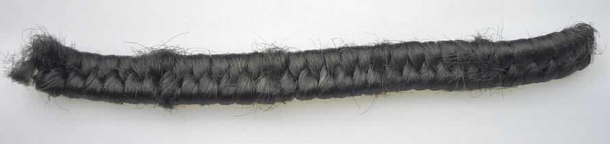 Spinnstoffe, für die Herstellung von Perücken zugerichtet, sog. Haarkrepp, Foto siehe Anlage,
- Krepp, bestehend aus einer Unterlage aus zwei parallel gelegten Schnüren,
- mit einem Florband aus (laut Antrag) Spinnstoffen (Chemiefasern) umschlungen,
- mit dem Aussehen eines Geflechts,
- Meterware mit einer Länge von 2 Meter und einem Gewicht von ca. 100 Gramm,
- gilt als zur Herstellung von Perücken und ähnlichen Waren aufbereitet.

"Spinnstoffe, für die Herstellung von Perücken und ähnlichen Waren zugerichtet"