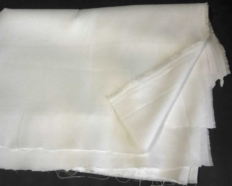 Gewebe, sog. Dekogrundware zum Bedrucken, Art. 050900, Foto siehe Anlage,
- als Meterware,
- mit einer Breite von lt. Antrag 150 cm,
- lt. Untersuchungsergebnis:
-- aus ungezwirnten, nicht hochfesten Garnen aus synthetischen Filamenten (lt. Antrag: Polyester) 
   und Polyester-Spinnfasern (synthetische Spinnfasern),
-- mit einem Gesamtanteil an synthetischen Filamenten von 65,5 GHT und an synthetischen 
   Spinnfasern von 34,5 GHT,
-- rohweiß,
-- druckvorbehandelt,
-- in Leinwandbindung.

"Gewebe aus Garnen aus synthetischen Filamenten, anderes als in den Unterpositionen 5407 10 bis 5407 84 genannte, roh"