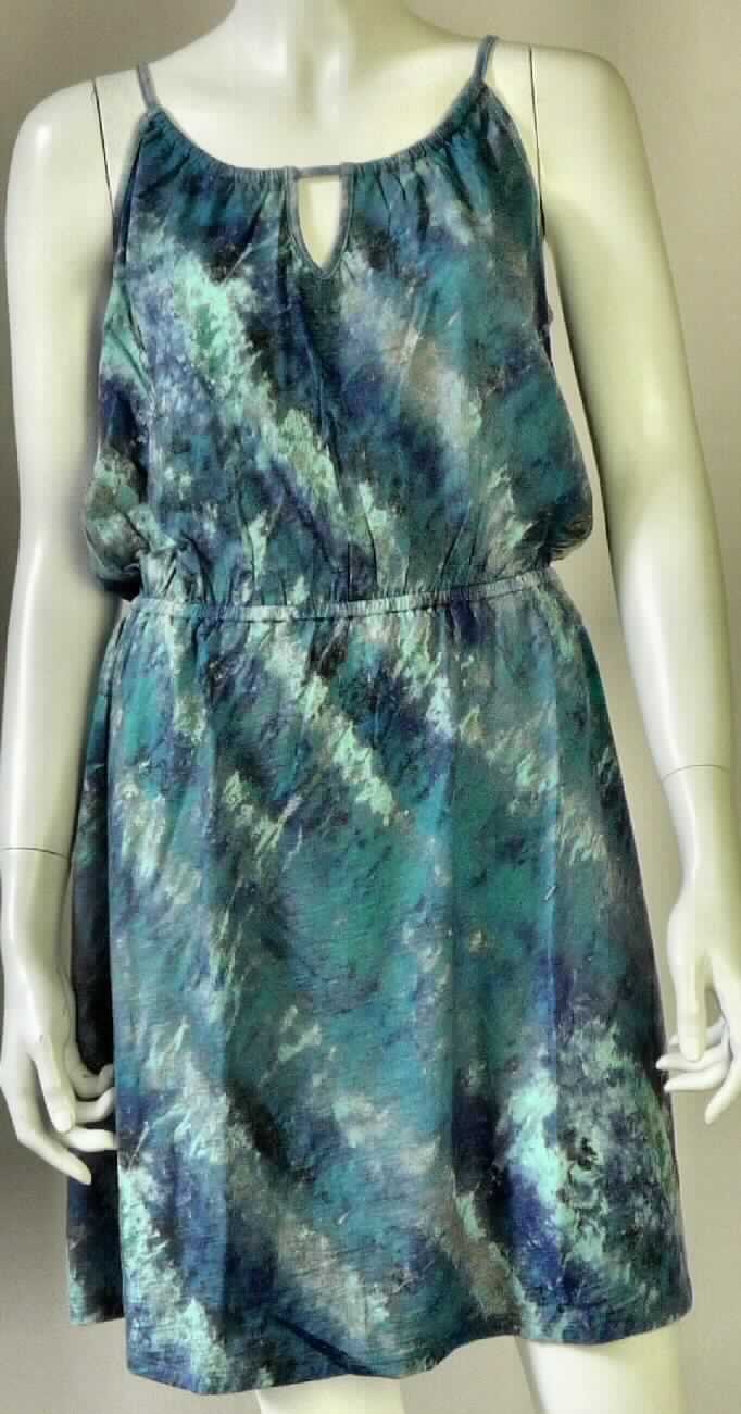 Kleid, sog. W04019 Berrima Dress, Größe S, Foto siehe Anlage,
- aus ca. 0,6 mm dicken, bedruckten Gewirken aus laut Antrag 100 % Merinowolle,
- bis über den halben Oberschenkel reichend (Rückenlänge: ca. 86 cm),
- ohne Öffnung und ohne Verschluss,
- mit schmalen Schulterträgern (sog. Spaghettiträger), die in den oberen Rand des Kleids eingezogen sind und 
  hinten gebunden werden,
- vorn und hinten mit einer V-förmigen Einkerbung, deren oberer Rand durch den "Bindeträger" gebildet wird,
- am unteren Rand durch Umschlagen und Festnähen gesäumt,
- kann aufgrund der Länge ohne ein weiteres, den Unterkörper bedeckendes Kleidungsstück getragen werden.

"Kleid, aus Gewirken, für Frauen, aus Wolle"