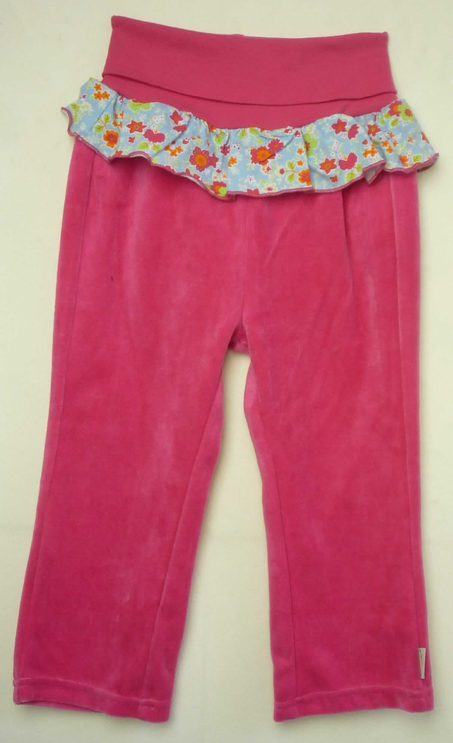 Lange Hose für Kleinkinder, sog. Hose (unisex), Größe 50, Art. 2801625, Foto siehe Anlage,
- die Ware wird durch ein Muster in Größe 92 veranschaulicht,
- aus ca. 1,5 mm dicken, einfarbigen Samtgewirken, laut Antrag mit einem Grund aus 100 % Polyester
  (synthetische Chemiefasern) und einem Flor aus 100 % Baumwolle,
- in der Taille abschließend; mit einem umgeschlagenen, elastischen Taillenbund,
- ohne Öffnung und ohne Verschluss, 
- unterhalb des Taillenbunds mit einer Rüsche aus bedruckten Gewirken aus laut Antrag 95 % Baumwolle und
  5 % Elasthan (synthetische Chemiefasern),
- mit knöchellangen Hosenbeinen,
- an den Beinabschlüssen durch Umschlagen und Festnähen gesäumt,
- insbesondere im Hinblick auf den Umfang sind die Samtgewirke die für die Spinnstoffermittlung maßgebenden 
  Flächenerzeugnisse,
- ist für Kleinkinder mit einer Körpergröße von bis zu 86 cm bestimmt, somit keine Ware der Position 6104.

"Kleidung, aus Gewirken, für Kleinkinder, aus Baumwolle"