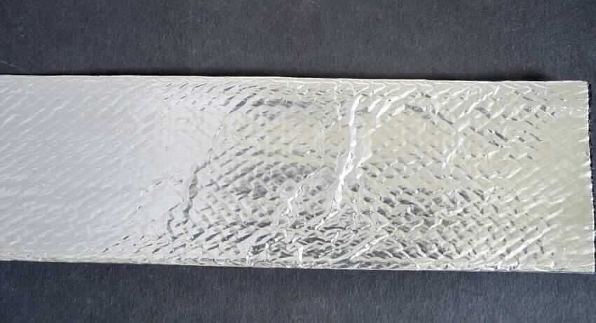Überzogenes Gewebe, sog. Langoflex Shield, Rundgeflecht aus PA, Foto siehe Anlage,
- als Meterware,
- aus einem schlauchförmigen Geflecht (Durchmesser ca. 3 cm) aus Monofilen aus lt. Antrag Polyamid 
  (synthetische Chemiefasern),
- auf der Außenseite mit dem bloßen Auge wahrnehmbar mit einer dünnen Folie aus lt. Antrag 
  selbstklebender Aluminiumfolie überzogen,
- soll als Schutzüberzug zur thermischen Isolierung verwendet werden, stellt sich somit nicht als 
  Pumpenschlauch der Position 5909 dar.

"Überzogenes Gewebe, anderes als in den Positionen 5901 bis 5906 und in der Unterposition 5907 0000 10 genannte"