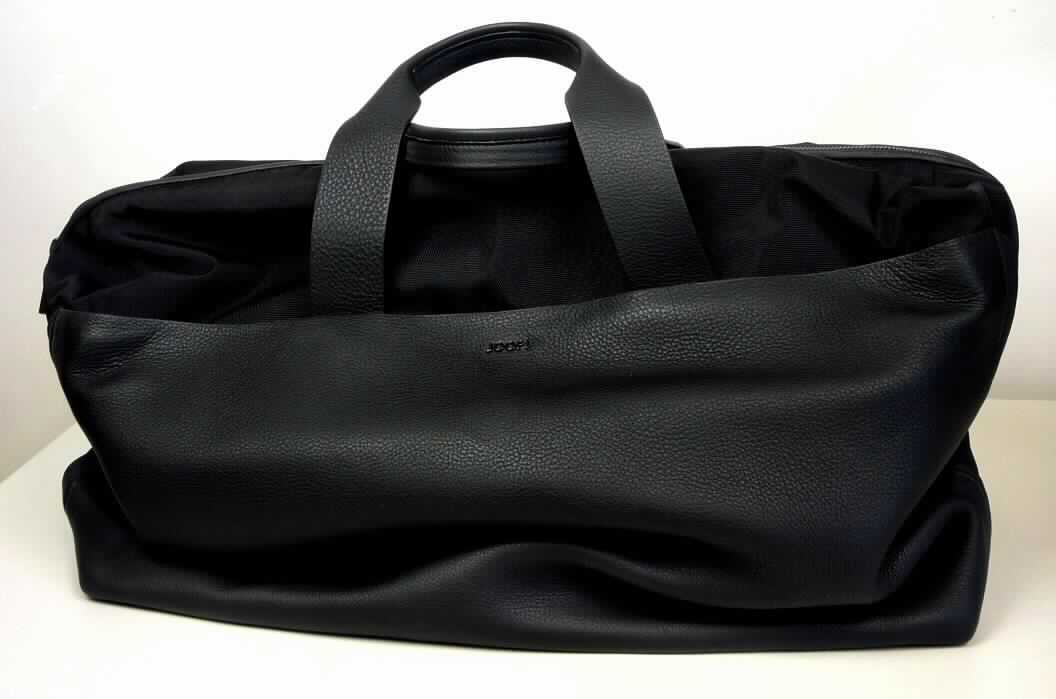Reisetaschenähnliches Behältnis, sog. Reisetasche Ottawa "DARINS", Art.-Nr. 414 000 1892, Abbildung siehe 
Anlage, 
- mit einer Außenseite aus flächenmäßig überwiegendem, charakterbestimmendem Leder und Spinnstoffen, 
- mit zwei Handtragegurten aus Leder und mit einem abnehmbaren, verstellbaren Schultertragegurt ausgestattet, 
- am Boden mit fünf Metallfüßchen, 
- an beiden Längsseiten mit einem verdeckten Reißverschlussfach ausgestattet, 
- an der Oberseite mit einem Doppelreißverschluss zum Öffnen des Hauptfachs, 
- innen mit einer lose eingelegten Bodenplatte, einem Reißverschlussfach und zwei Einsteckfächern, ansonsten 
  ohne weitere Einteilung oder Ausstattung; gefüttert, 
- nicht formstabil, mit den Abmessungen von ca. 51 (L) x 28 (B) x 38 (H) cm, 
- keine Hinweise auf Handarbeit, 
- verpackt in einer handelsüblichen Verkaufsumschließung.

"Ähnliches Behältnis, anderes als in den Unterpositionen 4202 1110 bis 4202 3900 genannte, mit Außenseite aus 
 Leder, anderes als in den Unterpositionen 4202 9110 genannte, nicht handgearbeitet"