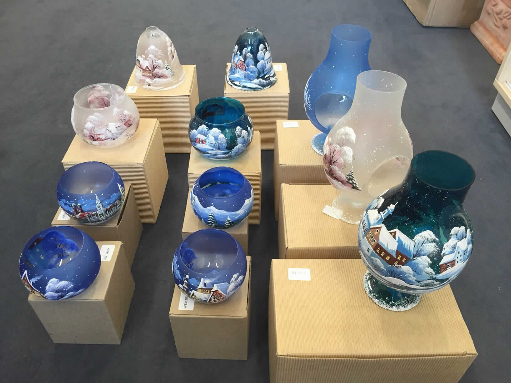 Glaswaren zur Innenausstattung, Foto siehe Anlage,
- lt. Antrag aus gewöhnlichem Glas,
- lt. Antrag handgefertigt (manuelle Glasentnahme),
- sog. Windlichtschalen, Artikel: WS 177.1, WS 177.2, WSkl 135.1, WSkl 150.1, WSkl 150.3 und WSkl 150.5:
- - oben offene, bauchige Gefäße,
- - mit einem Durchmesser von 11 cm und einer Höhe von ca. 9 cm (Artikel: WS 177.1 und WS 177.2)
    bzw. einem Durchmesser von ca. 10 cm und einer Höhe von ca. 8 cm (WSkl 135.1, WSkl 150.1, WSkl 150.3
    und WSkl 150.5),  
- sog. Windlichtlampen, Artikel: WL 117, WL 177.1 und WL 177.2:
- - leicht bauchige, oben offene Gefäße mit Standfuß,
- - mit einem Durchmesser von ca. 12 cm und einer Höhe von ca. 22 cm,
- - im unteren Drittel mit einer kreisrunden Öffnung zum Einstellen eines Teelichts oder einer anderen Kerze,
- sog. Windlichtglocken, Artikel: WG 177.1 und 177.2:
- - zweiteilig,
- - - mit einem glockenförmigen Oberteil mit einer Öffnung am oberen Ende (mit einem Durchmesser von
      ca. 12 cm und einer Höhe von ca. 11 cm,) und einem tellerförmigen Unterteil (Durchmesser: ca. 13 cm),
- die Außenseiten sind mit einem winterlichen Motiv (u. a. verschneite Landschaft und Häuser) bemalt,
- keine Weihnachtsfestartikel der Position 9505, da ein festlicher Bezug nicht vorhanden ist
  (die Waren sind lediglich mit winterlichen und nicht mit weihnachtlichen Motiven verziert),
- keine Einreihung als nicht elektrische Beleuchtungskörper in die Position 9405, da die Waren weder eine
  passgenaue Vorrichtung für ein handelsübliches Teelicht noch einen Dorn oder eine andere 
  Befestigungsmöglichkeit für eine Kerze aufweisen.

"Glaswaren zur Innenausstattung, aus gewöhnlichem Glas, handgefertigt (manuelle Glasentnahme)"