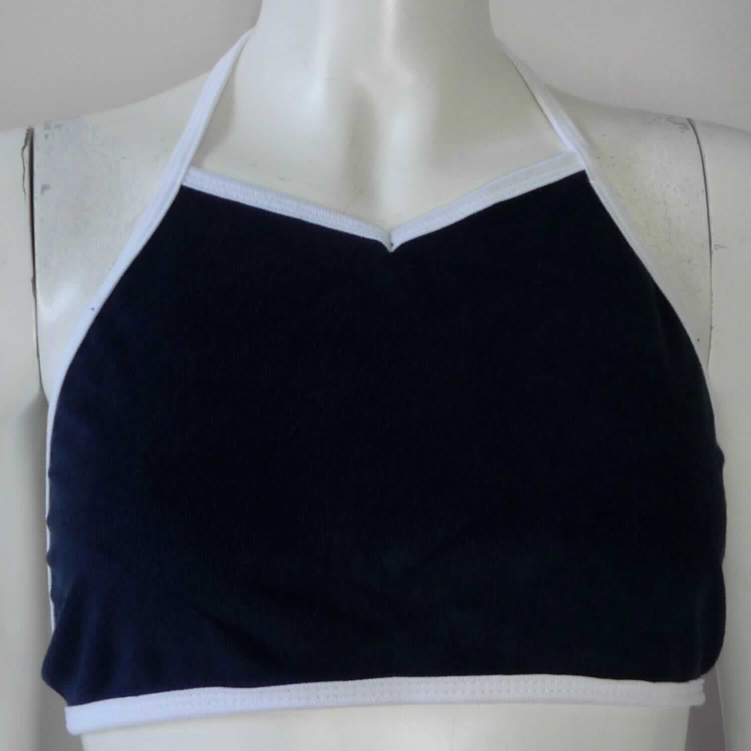 Kurzshirt, sog. kurzes Stricktop, Art. RSA9381, Größe XS/S, Foto siehe Anlage,
- aus ca. 1,7 mm dicken, einfarbigen Schlingengewirken aus lt. Antrag 80 % Baumwolle und 20 % Polyester 
  (synthetische Chemiefasern); mit einer Schlingenoberfläche aus laut Antrag Baumwolle,
- bis kurz unter die Brust reichend (max. Rückenlänge: ca. 32 cm), 
- mit einem annähernd trapezförmig gearbeiteten Vorderteil,
- schulterfrei; mit schmalen, ca. 1 cm breiten Schulterträgern, die vorn in der Verlängerung die seitliche 
  Randeinfassung bilden und im Nacken verknotet werden (sog. Neckholder),
- unterhalb der Brust mit einer Randeinfassung aus Gewirken aus Spinnstoffen, die in der Verlängerung die im 
  Rücken zu verknotenen Bindebänder bildet.


"Kleidung, andere als in den Positionen 6101 bis 6113 genannte, aus Gewirken, aus Baumwolle"