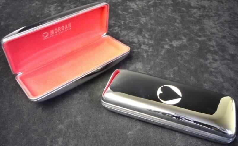 Brillenetui, Taschen- oder Handtaschenartikel, Abbildung siehe Anlage,
- mit einer Außenseite aus unedlem Metall,
- mit Abmessungen von ca. 16 x 6 x 3 cm (bzw. 4 cm),
- mit einer rechteckigen bzw. ovalen Seitenansicht,
- mit einem Deckel mit Schnappverschluss, auf der Rückseite mit einem Scharnier,
- innen mit Scherstaub beflockt,
- keine Hinweise auf Handarbeit.

"Brillenetui (Taschen- oder Handtaschenartikel), mit einer Außenseite aus unedlen 
 Metallen, nicht handgearbeitet"