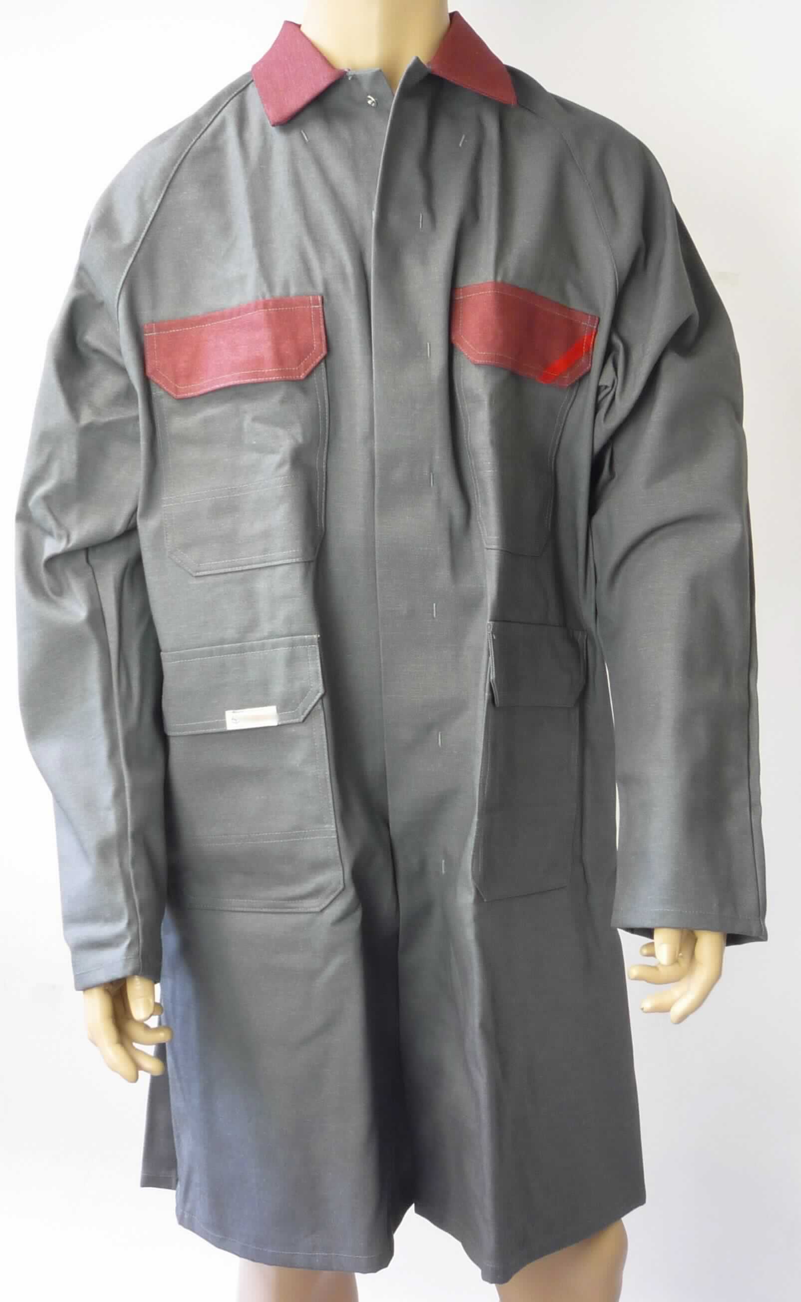 Kittel, sog. Herren Kittel, Größe 52, Foto siehe Anlage,
- aus ca. 0,7 mm dicken, einfarbigen, strapazierfähigen Geweben aus laut Antrag 58 % Baumwolle, 30 % Polyester, 
  11 % Basofil (beides synthetische Chemiefasern) und 1 % Carbon (Kohlenstofffasern), 
- über den halben Oberschenkel reichend (Rückenlänge: ca. 105 cm); damit weder eine Ware der Position 6203 
  noch der Position 6205,
- mit einem Umlegekragen,
- vorn mit einer durchgehenden Öffnung mit Druckknopfverschluss von links über rechts (Männerkleidung),
- mit langen Ärmeln,
- vorn mit zwei aufgesetzten Taschen im Brustbereich und zwei aufgesetzten Taschen unterhalb der Taille; alle
  Taschen sind mit einer Patte mit Druckknopfverschluss ausgestattet,
- am unteren Rand durch Umschlagen und Festnähen gesäumt,
- erkennbar dazu bestimmt, ausschließlich oder hauptsächlich zum Schutz anderer Kleidungsstücke und/oder 
  Personen bei Ausübung einer Gewerbe-, Berufs- oder Haushaltstätigkeit getragen zu werden,
- wird im Allgemeinen nicht über jeder anderen Kleidung und zum Schutz gegen das Wetter getragen, somit kein
  Mantel.

"Andere Kleidung (Kittel), aus Geweben, für Männer, aus Baumwolle, Arbeits- und Berufskleidung"