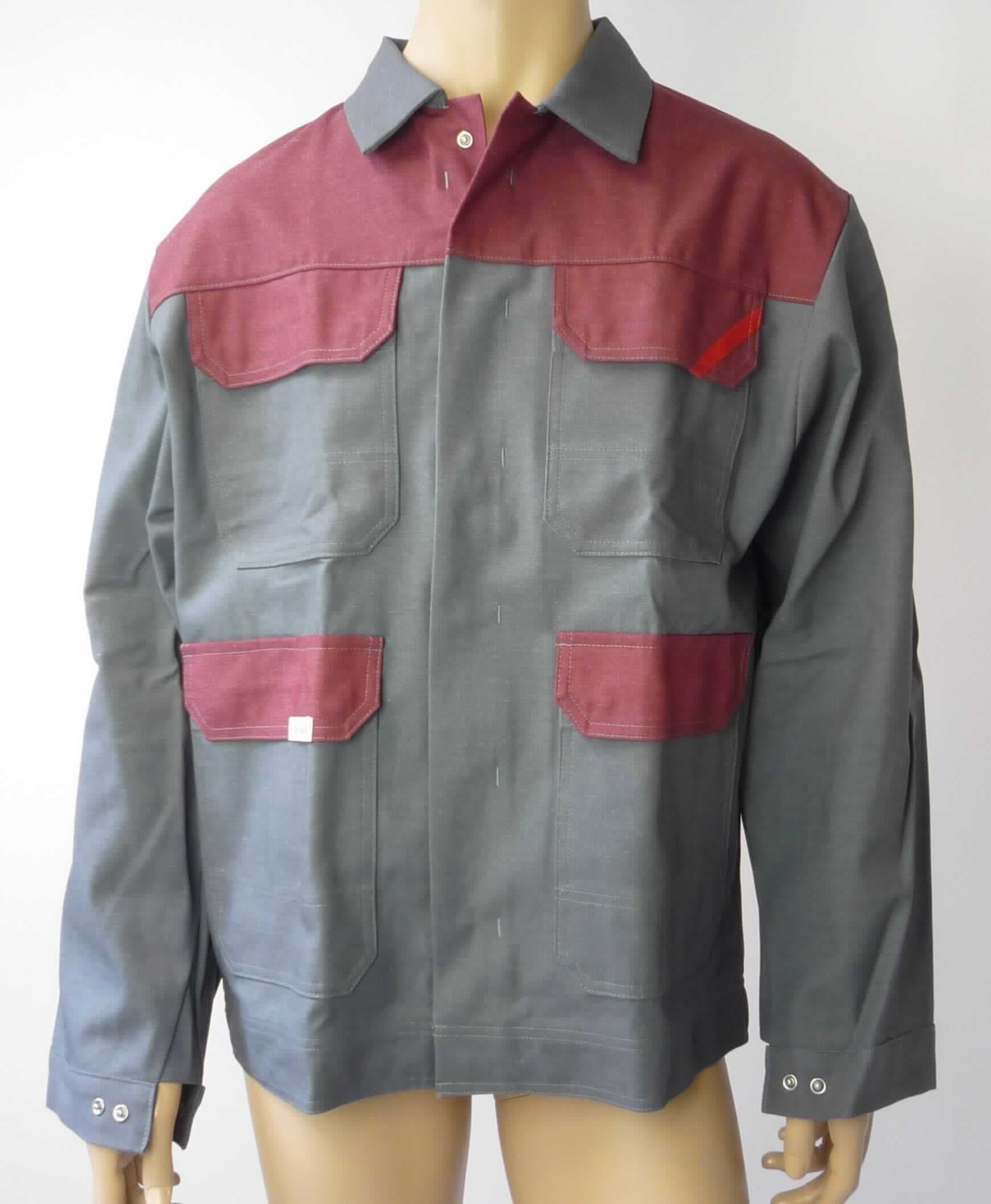 Jacke, sog. Bundjacke, Foto siehe Anlage,
- aus ca. 0,6 mm dicken, buntgewebten, strapazierfähigen Geweben aus laut Antrag 58 % Baumwolle, 
  30 % Polyester, 11 % Basofil (beides synthetische Chemiefasern) und 1 % Carbon (Kohlenstofffasern), 
- über den Schritt reichend (Rückenlänge: ca. 75 cm),
- mit einem Umlegekragen,
- vorn mit einer durchgehenden Öffnung mit Druckknopfverschluss von links über rechts (Männerkleidung),
- mit langen Ärmeln, an den Ärmelenden mittels Druckknopfverschluss zu verengen,
- vorn mit zwei aufgesetzten Taschen im Brustbereich und zwei aufgesetzten Taschen unterhalb der Taille; alle
  Taschen sind mit einer Patte mit Druckknopfverschluss ausgestattet,
- am unteren Rand durch Umschlagen und Festnähen in der Art eines ca. 4,5 cm breiten Bundes gesäumt,
- aufgrund des strapazierfähigen Materials und des zweckbestimmten, einfachen Schnitts erkennbar dazu 
  bestimmt, ausschließlich oder hauptsächlich zum Schutz der Person und/oder der Kleidung getragen zu 
  werden (somit Arbeits- und Berufskleidung),
- wird im Allgemeinen nicht über jeder anderen Kleidung und zum Schutz gegen das Wetter getragen, somit keine 
  Ware der Position 6201.

"Jacke, aus Geweben, für Männer, aus Baumwolle, Arbeits- und Berufskleidung"