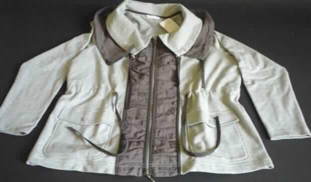 Jacke, sog. Sweatjacke, Größe XL, siehe Foto,
- charakterbestimmend (nach dem Umfang) aus 1,2 mm dicken, melierten Gewirken aus lt. Antrag 
  95 % Baumwolle und 5 % Elasthan (synthetische Chemiefasern), , 
- im Bereich der Öffnung, des Kragens und auf der Rückennaht mit aufgenähten Zuschnitten 
  aus einfarbigen Geweben aus lt. Antrag Chemiefasern,
- über die Taille reichend (Rückenlänge: 67 cm),
- mit einem breiten, doppelten Kragen,
- vorn mit einer durchgehenden Öffnung mit Reißverschluss,
- ohne Merkmale auf den Trägerkreis (unisex), 
- mit langen Ärmeln, 
- in der Taille mit einem Tunnelzug zu verengen,
- in sechs Längsteilen (Bahnen) gearbeitet; ungefüttert,
- mit zwei aufgesetzten Taschen unterhalb der Taille (u. a. somit keine Ware der Position 6106),
- am unteren Rand gesäumt,
- kennzeichnet sich aufgrund des allgemeinen Aussehens, einer gewissen Formfestigkeit, der Aus-
  stattung und des Materials als Jacke der Position 6104 (somit keine Strickjacke der Position 6110),
- wird nicht als äußerstes Kleidungsstück über jeder anderen Kleidung getragen (u. a. somit kein  
  Kleidungsstück der Position 6102).