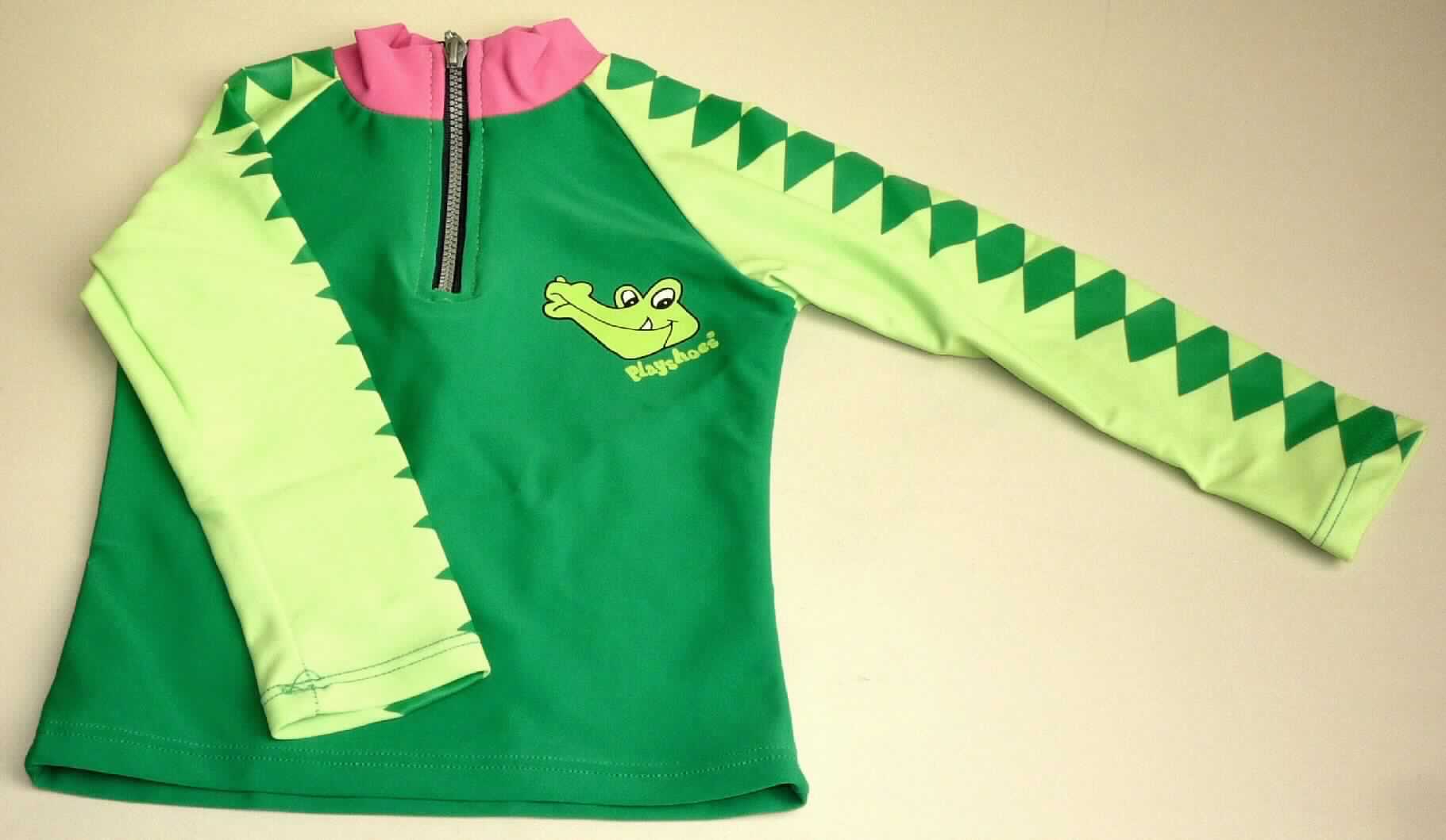 Kleidung für Kleinkinder, sog. Jungen+Mädchen-Schwimmshirt, Artikel 2541405, Größe 74/80, Foto siehe Anlage,
- aus verschiedenen, etwa 0,6 mm dicken, einfarbigen Gewirken aus laut Antrag 82% Polyamid und 18% Elasthan
  (Elastomergarn, beides synthetische Chemiefasern); ohne Kautschukfäden; an den Ärmeln mit einem Karomuster,
  vorn und hinten mit einem Krokodilmotiv bedruckt,
- über die Taille reichend (Rückenlänge: etwa 30 cm),
- mit einem Stehkragen,
- vorn mit einer teilweisen Öffnung mit einem bis in die Kragenspitzen reichenden Reißverschluss,
- mit langen Ärmeln,
- am unteren Rand durch Umschlagen und Festnähen gesäumt,
- aufgrund der Größe für Kinder unter 18 Monaten bestimmt, somit Kleidung für Kleinkinder.

"Kleidung, aus Gewirken, für Kleinkinder, aus synthetischen Chemiefasern"
