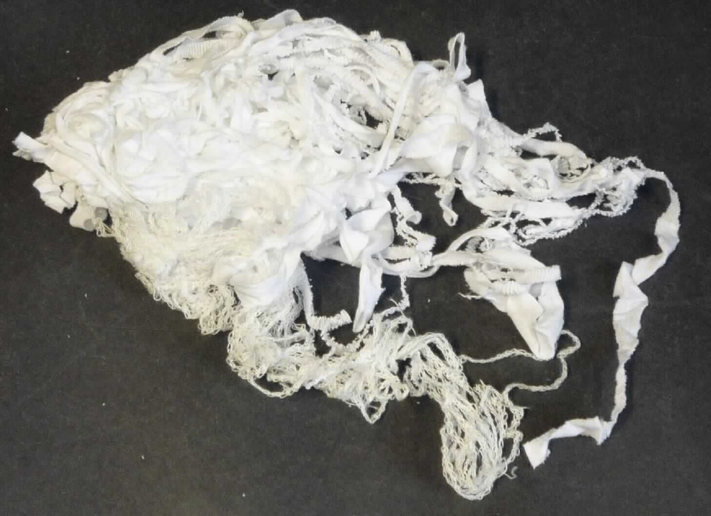 Lumpen aus Spinnstoffen, sog. Muster Nr. 8, Bändchen, weiß, Foto siehe Anlage, 
- die Waren werden durch Spinnstoffabschnitte in Form von sog. Kanten- und Schneideabfällen aus 
  einfarbigen (weiß) Gewirken aus Spinnstoffen veranschaulicht,
- die Spinnstoffabschnitte fallen laut Antrag beim Produktionsprozess an,
- in unterschiedlicher Form unregelmäßig zugeschnitten (in Abmessungen von weniger als 100 cm x 100 cm); 
  anders als quadratisch oder rechteckig (somit konfektioniert),
- sortiert, da alle Schnittabfälle laut Antrag aus Kanten- und Schneideabfällen aus weißen Gewirken aus
  Spinnstoffen bestehen,
- es handelt sich nicht um gezielt zugeschnittene Abschnitte, somit sind die Spinnstoffabschnitte keine Waren 
  der Position 6307,
- dient laut Antrag zur Rohstoffgewinnung.

"Lumpen, aus Spinnstoffen, sortiert"