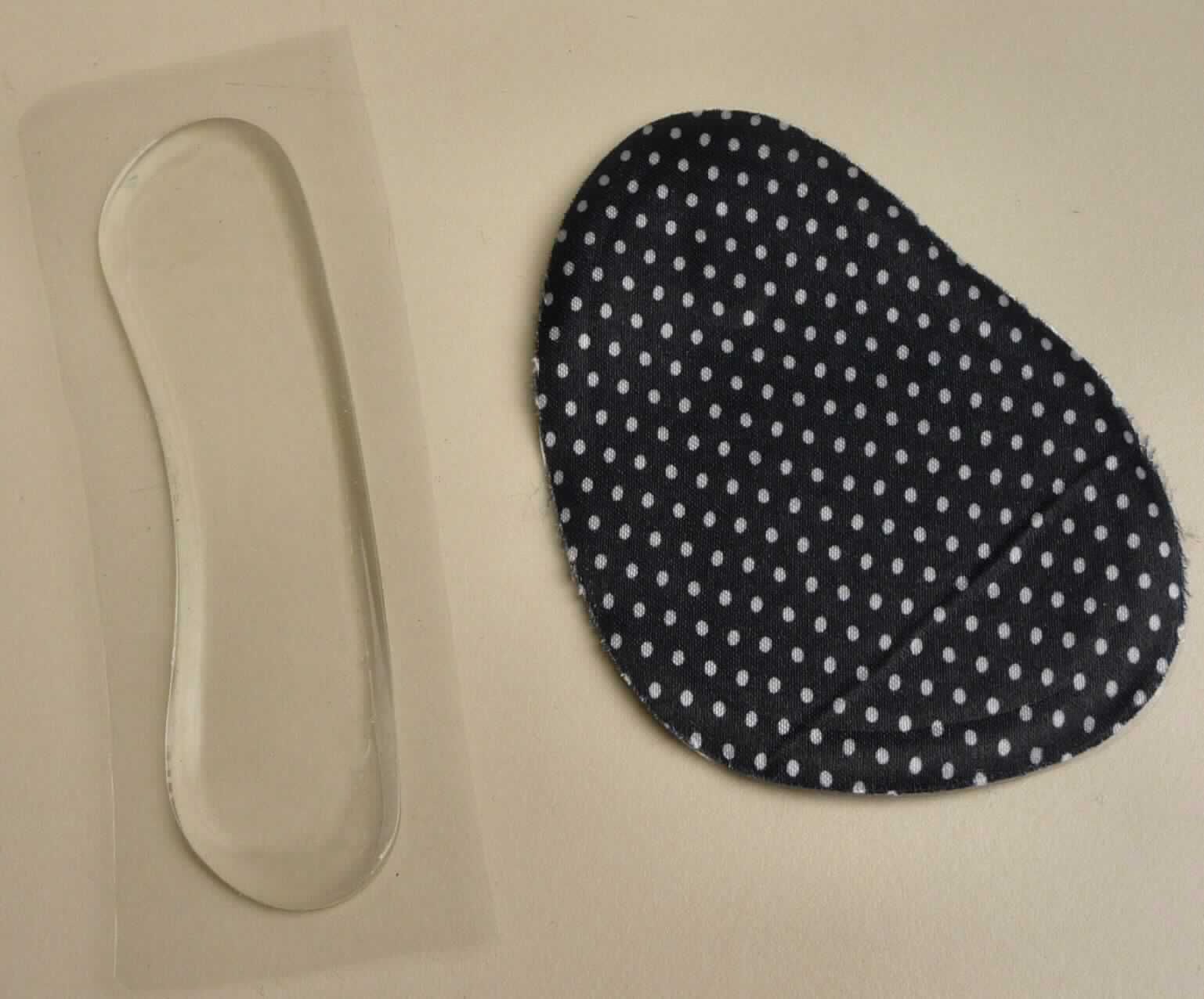 Schuheinlagen (lt. Antrag: "Fußpads für Ferse und Ballen", Foto siehe Anlage),
- herausnehmbares Zubehör in Form eines klarsichtigen Fersenpolsters aus Kunststoff 
  (lt. Antrag Silikon) und eines Fußballenpolsters aus Kunststoff mit Oberlage aus Spinnstoff,
- zum Einsetzen in den Fersen- und Ballenbereich von Schuhen bestimmt,
- fixierbar,
- in den Abmessungen: ca. 10 cm x 2 cm (Fersenpolster) bzw. ca. 8,5 cm x 6 cm (Fußballenpolster),
- nicht handgearbeitet

"Herausnehmbares Zubehör für Schuhe (Fersen- und Ballenpolster), nicht handgearbeitet"
