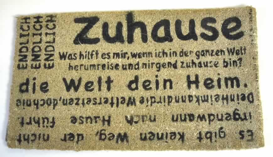 Fußbodenbelag (Fußabtreter), sog. Fußmatte Zuhause, Artikelnummer: 3772349, siehe beigefügtes
Foto,
- rechteckig; in den Abmessungen: ca. 77 cm x 44 cm,
- mit einer Dicke von ca. 2,5 cm, 
- gewebt aus lt. Antrag Kokos (Spinnstoff; kein Flechtstoff),
- kein Kelim, Sumak, Karamanie oder denen ähnlicher handgewebter Teppich,
- weder getuftet noch beflockt,
- bedruckt,	
- die Spinnstoffe bilden die Schauseite der Ware bei deren Verwendung; die Ware weist aufgrund
  seiner Dicke, Steifheit und Widerstandsfähigkeit die charakteristischen Merkmale eines
  Fußbodenbelags auf.