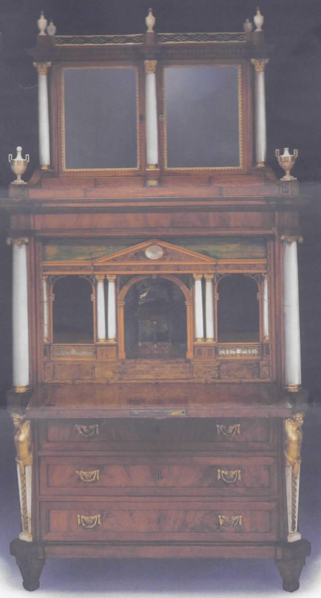 Mahagony-Sekretär "Berlin" (s. Foto) aus der Tochterwerkstatt von David Roentgen, Berlin, ca. 1800.
Das Möbel besitzt einen Korpus aus Eichen- und Nadelholz und ist mit Mahagoni furniert. Die  Beschläge sind aus vergoldeter Bronze, die Säulen und Urnen aus Marmor. Als Marketerie wurden Schildpatt, Perlmutt, gefärbte Hölzer und Maserhölzer verwendet.

Das Möbel besteht aus einem dreischübigen Kommodenteil, einer Schreibklappe und einem zweitürigen Aufsatz mit von Marmorsäulen flankierten Spiegeln. Eine durchbrochenen Galerie mit Marmorurnen bildet den oberen Abschluss des Möbels. Sechs Marmorsäulen tragen ein über drei offene Fächer reichendes Gesims. Unter diesen befinden sich drei in die Architektur integrierte Laden. 
Charakterbestimmend im Hinblick auf die Materialbeschaffenheit sind die Bestandteile aus Holz.
 
Das Möbel stammt aus der 1791 von David Röntgen mit königlichem Privileg gegründeten Tochterwerkstatt, die seinerzeit von David Hacker geleitet wurde. Es ist damit von geschichtlichem Wert.

Maße: Höhe 203 cm, Breite 110 cm, Tiefe  52 cm.


Die beschriebene Ware ist als "Sammlungsstück von geschichtlichem Wert, aus Holz" einzureihen.