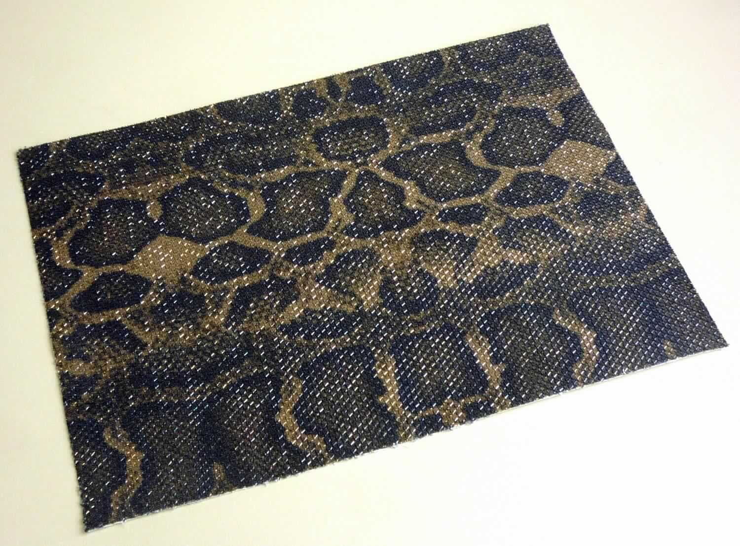 Textillaminat, sog. Stoff, Foto siehe Anlage,
- als Meterware, laut Antrag mit einer Breite von 125 cm,
- laut Untersuchungsergebnis:
-- aus zwei mit ihrer ganzen Fläche aufeinanderliegenden und so miteinander durch Kleben verbundenen Lagen:
--- mit einer Oberlage (Schauseite):
---- aus einem bedruckten Kuliergewirke aus überwiegend synthetischen Chemiefasern (laut Antrag: Polyester)
      und metallisierten Streifen aus synthetischer Spinnmasse (laut Antrag: Polyester) der Position 5605,
---- keine Elastomergarne oder Kautschukfäden enthaltend,
---- nicht für Vorhänge und Gardinen,
--- mit einer Unterlage:
---- aus einem gebleichten Gewebe in Leinwandbindung aus laut Antrag Baumwolle,
- im Hinblick auf die Verwendung verleiht das die Schauseite bildende Kuliergewirke der Ware ihren wesentlichen
  Charakter.

"Gewirke, anderes als in den Position 6001 bis 6005 genannte, aus synthetischen Chemiefasern, bedruckt,
 anderes als für Vorhänge und Gardinen"