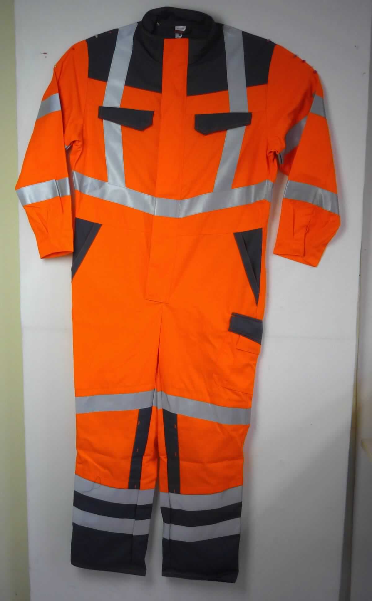 Overall, sog. Sicherheitskleidung, Größe 52/54, Foto siehe Anlage,
- aus ca. 0,5 mm dicken, verschiedenen einfarbigen, strapazierfähigen Geweben aus laut Antrag 50 % Baumwolle
  und 50 % Polyester (synthetische Chemiefasern),
- einteilig; den ganzen Körper mit Ausnahme von Kopf, Händen und Füßen bedeckend,
- mit einem Stehkragen,     
- vorn mit einer bis zum Schritt reichenden Öffnung mit Reißverschluss, verdeckt von einer Patte mit Druckknopf-
  verschluss von links über rechts (Männerkleidung),
- im Bereich der Taille teilweise elastisch verengt,
- mit langen Ärmeln, an den Ärmelenden mittels Druckknopfverschluss zu verengen,
- mit verschiedenen ein- und aufgesetzten Taschen,
- mit aufgenähten, reflektierenden Streifen versehen,
- an den Beinabschlüssen durch Umschlagen und Festnähen gesäumt,
- u. a. aufgrund des zweckbestimmten Schnitts, des strapazierfähigen Materials und der Ausstattung erkennbar 
  dazu bestimmt, ausschließlich oder hauptsächlich zum Schutz anderer Kleidungsstücke und/oder Personen bei 
  der Ausübung einer Gewerbe- oder Berufstätigkeit getragen zu werden,
- aufgrund der Materialzusammensetzung keine Ware der Unterposition 6211 32.

"Andere Kleidung (Overall), aus Geweben, für Männer, aus Chemiefasern, Arbeits- und Berufskleidung"