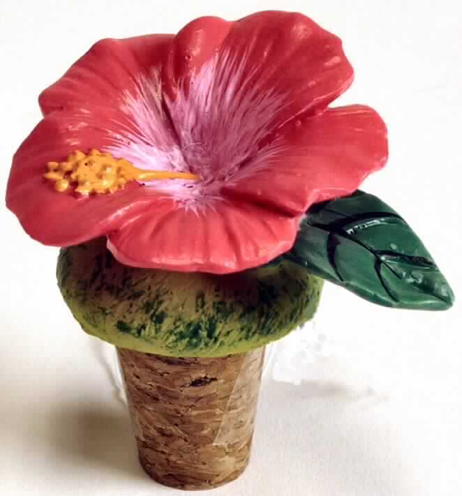Flaschenverschluss, bestehend aus einem ca. 3,0 cm langen, konisch geformten Stopfen aus Presskork, der mit einem ca. 3,0 cm hohen, besonders gestalteten Griff aus Kunstharz in Form einer Hibiskusblüte verziert ist.
Der konische Korkenstopfen gewährleistet die für die offensichtlich mehrfache Verwendung des Erzeugnisses maßgebliche Verschlussfunktion und ist daher als charakterverleihend anzusehen.

Zolltarifrechtlich handelt es sich um eine "Ware aus Presskork, andere als in UPos. 4504 10 genannt".