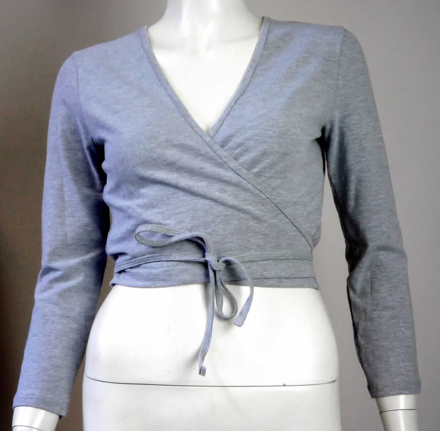 Bluse, sog. kurzes Stricktop für Frauen, Artikel RSA8394, Größe S, Foto siehe Anlage,
- aus ca. 0,5 mm dicken (leichten), buntgewirkten Gewirken (melierte Garne) aus laut Antrag 85 % Baumwolle,
  10 % Polyester und 5 % Elasthan (beides synthetische Chemiefasern); mit durchschnittlich mehr als 10 Maschen 
  in jeder Richtung je linearen Zentimeter,
- über die Taille reichend (Rückenlänge: ca. 42 cm),
- mit einem V-förmigen, sehr tiefen Halsausschnitt,
- mit langen Ärmeln,
- im Wickelstil gearbeitet, vorn mit einer durchgehenden Öffnung; am Halsausschnitt und an den schräg 
  gearbeiteten Vorderteilen mit einer zu Bindebändern auslaufenden Randeinfassung; die Bindebänder werden 
  durch eine kleine Öffnung an den Seiten (etwa 2 cm vom unteren Rand) geführt und im Rücken oder vorn 
  gebunden; mit Überlappung sowohl von rechts auf links als auch von links auf rechts (unisex), 
- am unteren Rand durch Umschlagen und Festnähen gesäumt,
- erfüllt die Merkmale zur Einreihung als Bluse, somit keine Ware der Position 6114.

"Bluse, aus Gewirken, für Frauen, aus Baumwolle"
