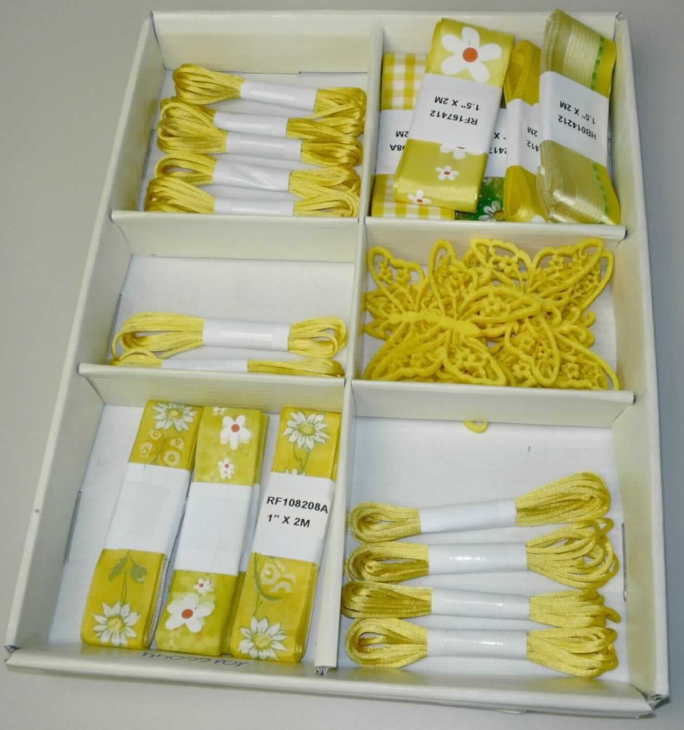 Dekoartikel, sog. Dekobänder im Display 60 tlg., Auftragsnr.: 10166044, Foto siehe Anlage,
- Zusammenstellung aus 12 "Dekobändern schmal", 24 "Dekobändern breit", 12 "Dekoseilen" und 
  12 "Filzschmetterlingen", in einer Pappschachtel verpackt,
- keine Warenzusammenstellung im Sinne der AV 3 b), da die Dekoartikel vom Endverbraucher einzeln erworben
  werden können und somit nicht für den Einzelverkauf aufgemacht sind,
- "Dekoseile":
-- aus einem schlauchgewebeähnlichen Erzeugnis in der Art einer Kordel (spiralartig in der Ware rund laufender 
   "Schussfaden"); jedoch kein Schlauchgewebe im Sinne der Anmerkung 5 Absatz 1 b) Kapitel 58,
-- mit einem Durchmesser von ca. 2 mm,
-- laut Antrag aus 100 % Nylon (synthetische Chemiefasern), 
-- mit einem Titer von ca. 20.000 dtex.

"Bindfäden, aus synthetischen Chemiefasern, aus Nylon, mit einem Titer von weniger als 50.000 dtex"