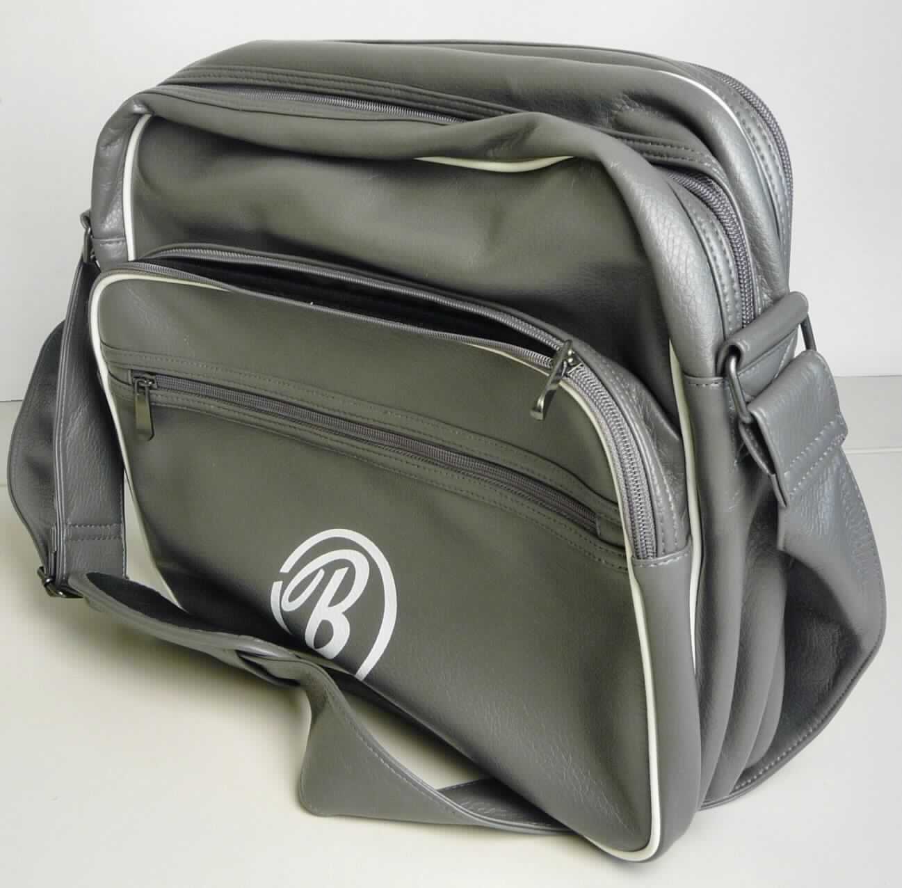 Aktentaschenähnliches Behältnis, sog. College Bag grau aus Polyurethan, Foto siehe Anlage, 
- mit einer Außenseite aus Kunststofffolien, 
- in den Abmessungen: ca. 42 cm (Breite) x 35 cm (Höhe) x 10 cm (Tiefe),
- mit einem verstellbaren Schultertragegurt mit Schulterpolster,
- vorn mit einem aufgedruckten Logo versehen,
- mit einem Vorfach mit Reißverschluss; mit einem darin eingesetzten Reißverschlussfach,
- mit einem Hauptfach mit Reißverschluss; innen mit einem gepolsterten Notebookfach mit
  einer Klettverschlussschlaufe, ansonsten ohne weitere Aufteilung; gefüttert,
- auf der Rückseite mit einem aufgesetzten Reißverschlussfach ausgestattet; innen mit einem
  eingesetzten Reißverschlussfach.

"Aktentaschenähnliches Behältnis, mit Außenseite aus Kunststofffolien"