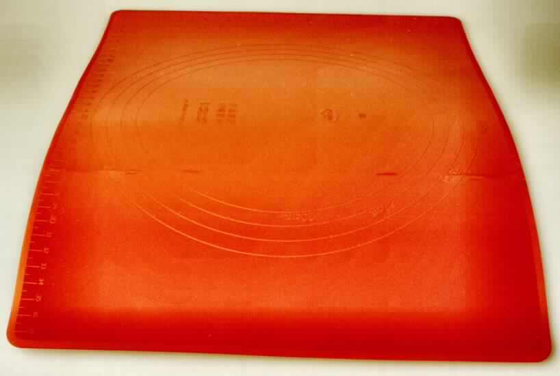 Das Erzeugnis ist eine so genannte Backmatte in Form einer ca. 30 x 38 cm großen Platte mit abgerundeten Ecken. Die Ware besteht aus Silikon, einem Kunststoff im Sinne der Anmerkung 1 zu Kapitel 39. Sie wird üblicherweise in der Küche als wiederverwertbare Backfolie verwendet. Das Erzeugnis ist in einem bedruckten Pappkarton aufgemacht.

Zolltariflich liegt ein "Artikel für den Tisch- oder Küchengebrauch, aus Kunststoffen" vor.